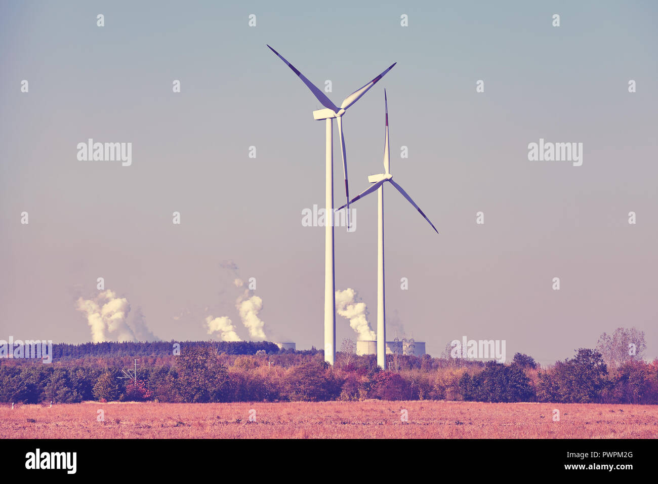 Windmühlen mit rauchenden Schloten im Hintergrund, Farbe getonte Bild. Stockfoto