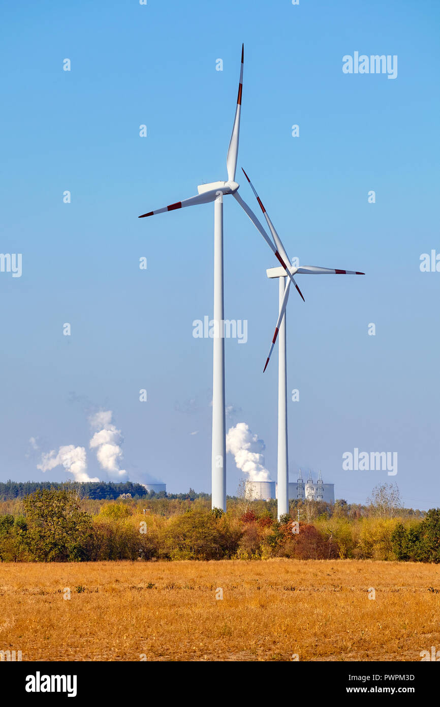 Windmühlen mit rauchenden Schloten im Hintergrund. Stockfoto