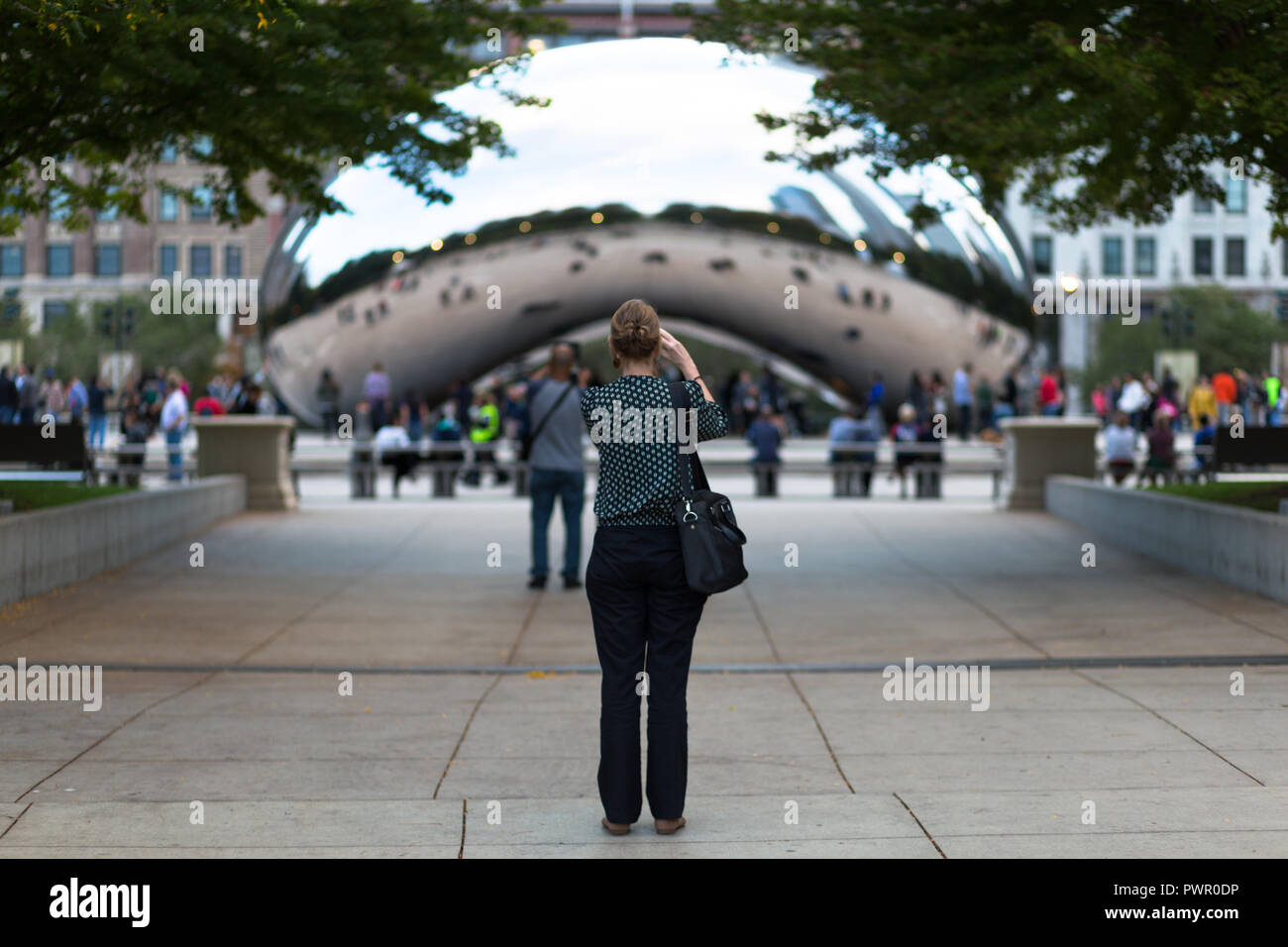 Frau unter Foto der Bean/Cloud Gate - Chicago, IL Stockfoto