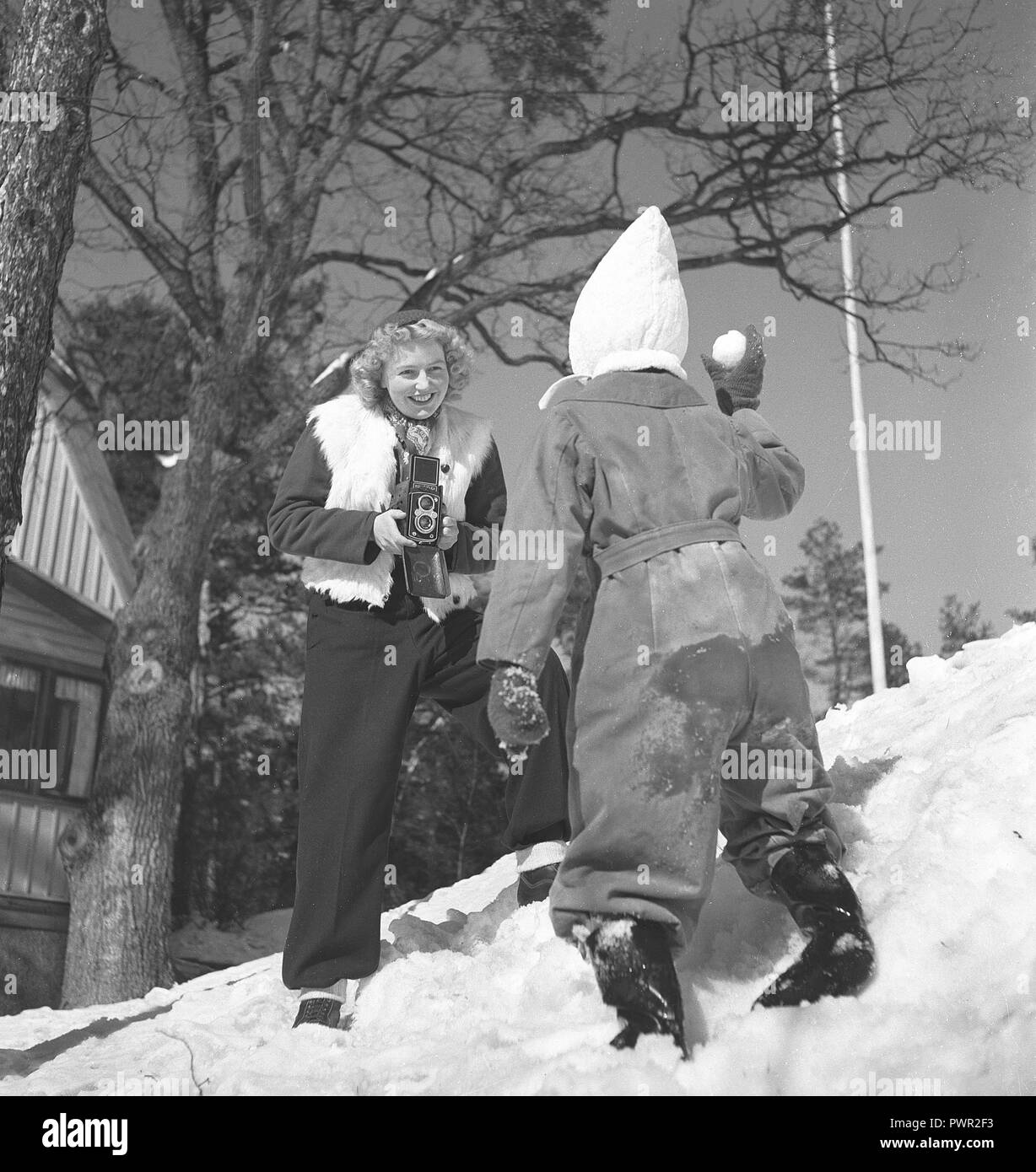 Winter in den 1940er Jahren. Eine junge Mutter ist Fotografieren ihre Tochter ein Wintertag. Die Kamera ist ein von der deutschen Firma Rollei Rolleiflex. Schweden 1944. Foto Kristoffersson Ref G 104-3 Stockfoto