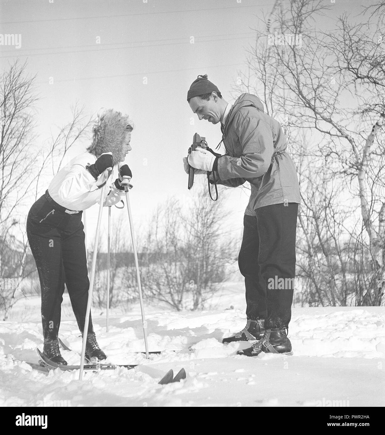 Winter in den 1940er Jahren. Schauspieler Nils Kihlberg, 1915-1965 ist hier mit seiner Frau Ann-Britt. Er nimmt Bilder von ihr auf ihren Winterurlaub. Sie sind beide trugen Winterkleidung und Skier. Die Kamera ist ein von der deutschen Firma Rollei Rolleiflex. Schweden 1940. Foto Kristoffersson Ref D 97-1 Stockfoto