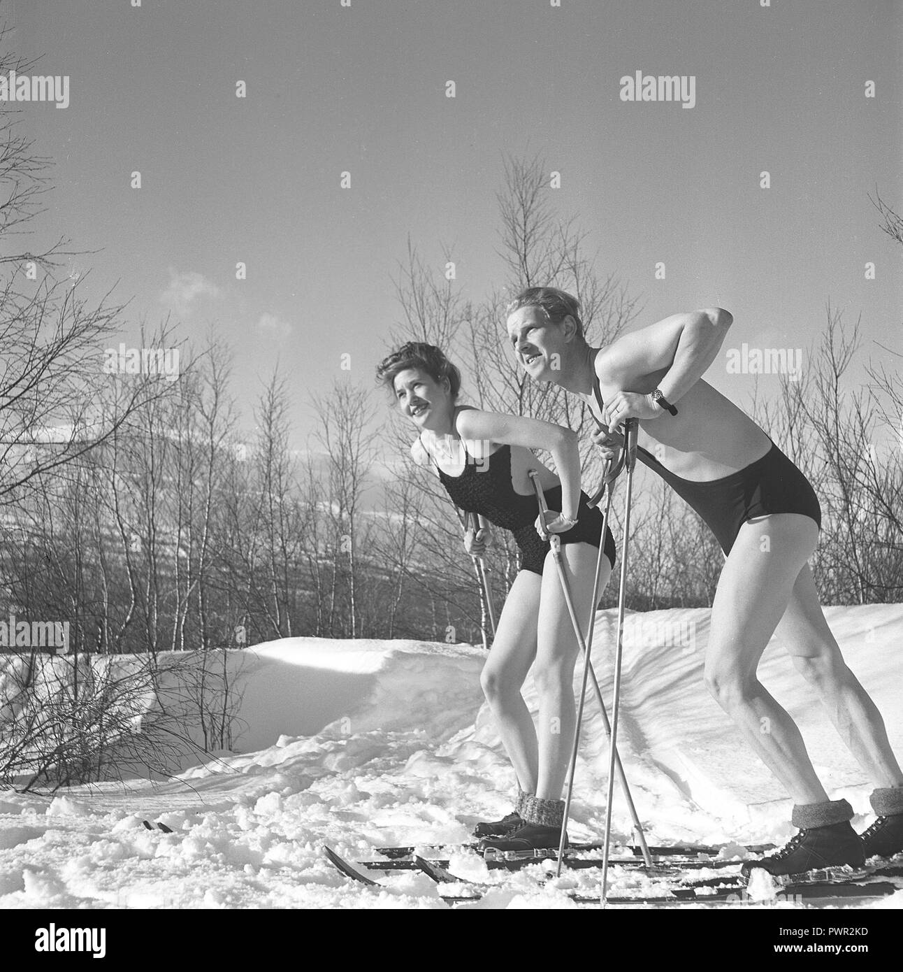 Winter in den 1940er Jahren. Ein junges Paar genießt ihren Winter Urlaub, und sie tragen ihre Badeanzüge eine schöne Bräune von draußen in der warmen Sonne zu erhalten. Schweden 1940. Foto Kristoffersson Ref D 115-4 Stockfoto