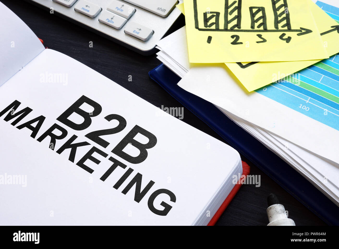 Buch über B2B-Marketing und Diagramme auf den Schreibtisch. Stockfoto