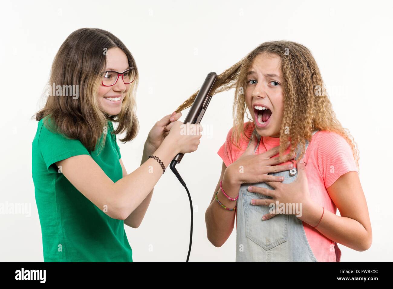 Portrait von zwei Jugendlichen Freundinnen Haarschnitt zuhause tun. Weißer Hintergrund. Stockfoto