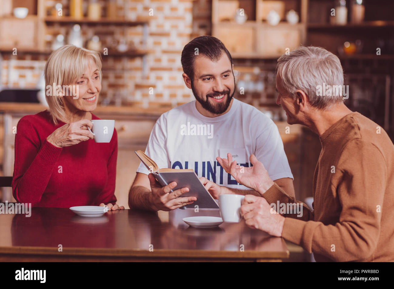 Glückliche Menschen am Tisch sitzen mit Rentner Stockfotografie - Alamy