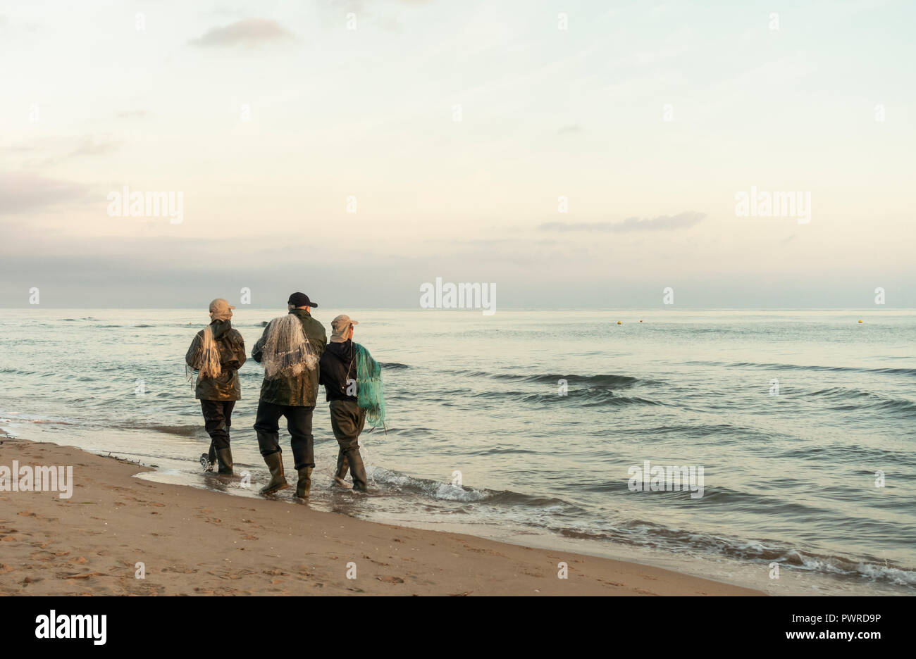 Spanische Männer mit Netzen von Strand an der Costa del Azahar, südlich von Valencia Stockfoto
