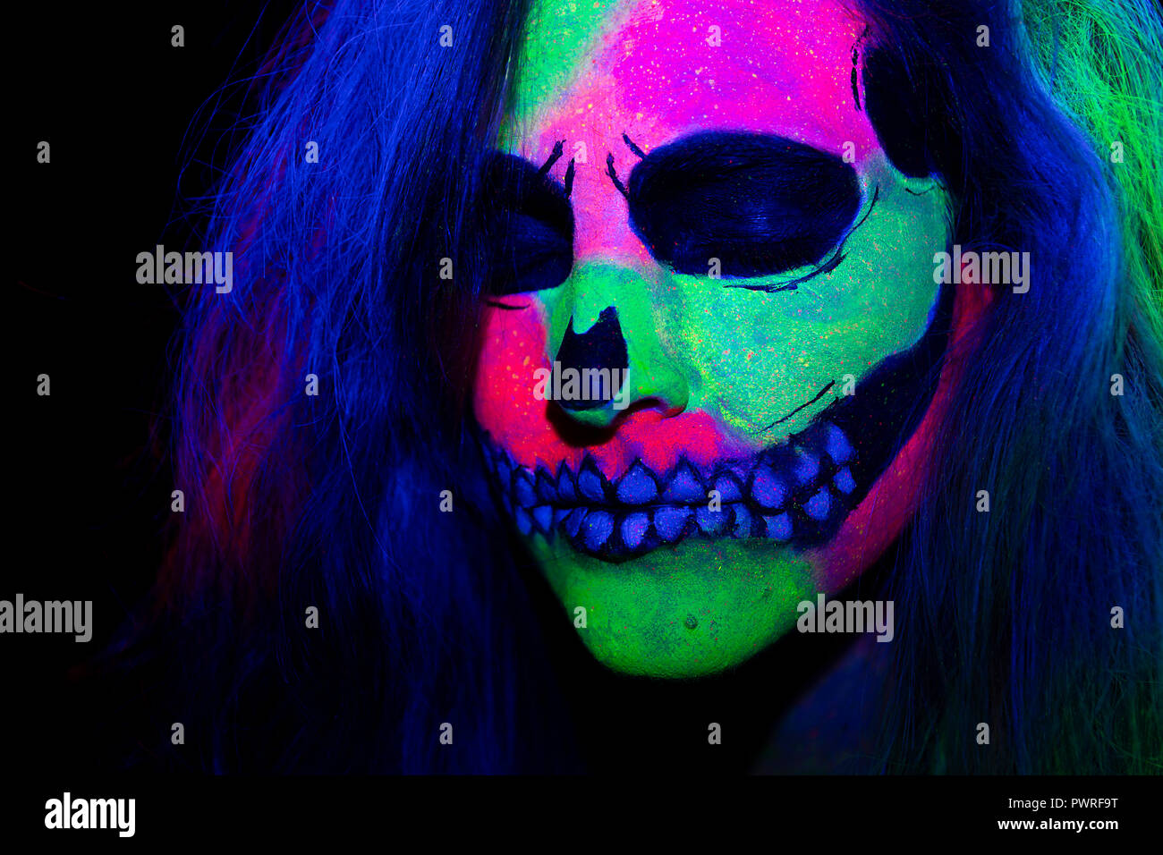 Frau Mit Ihrem Gesicht Malen Mit Neon Make Up Mit Einem Skull Design Fur Halloween Stockfotografie Alamy