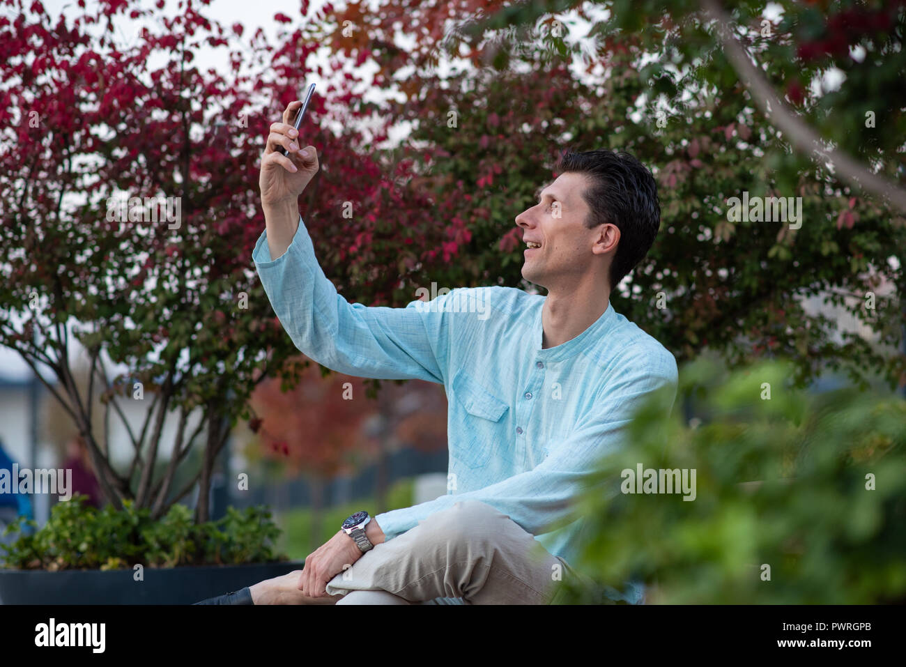 Schöner Mann unter selfie mit seinem Handy in einem Park Stockfoto
