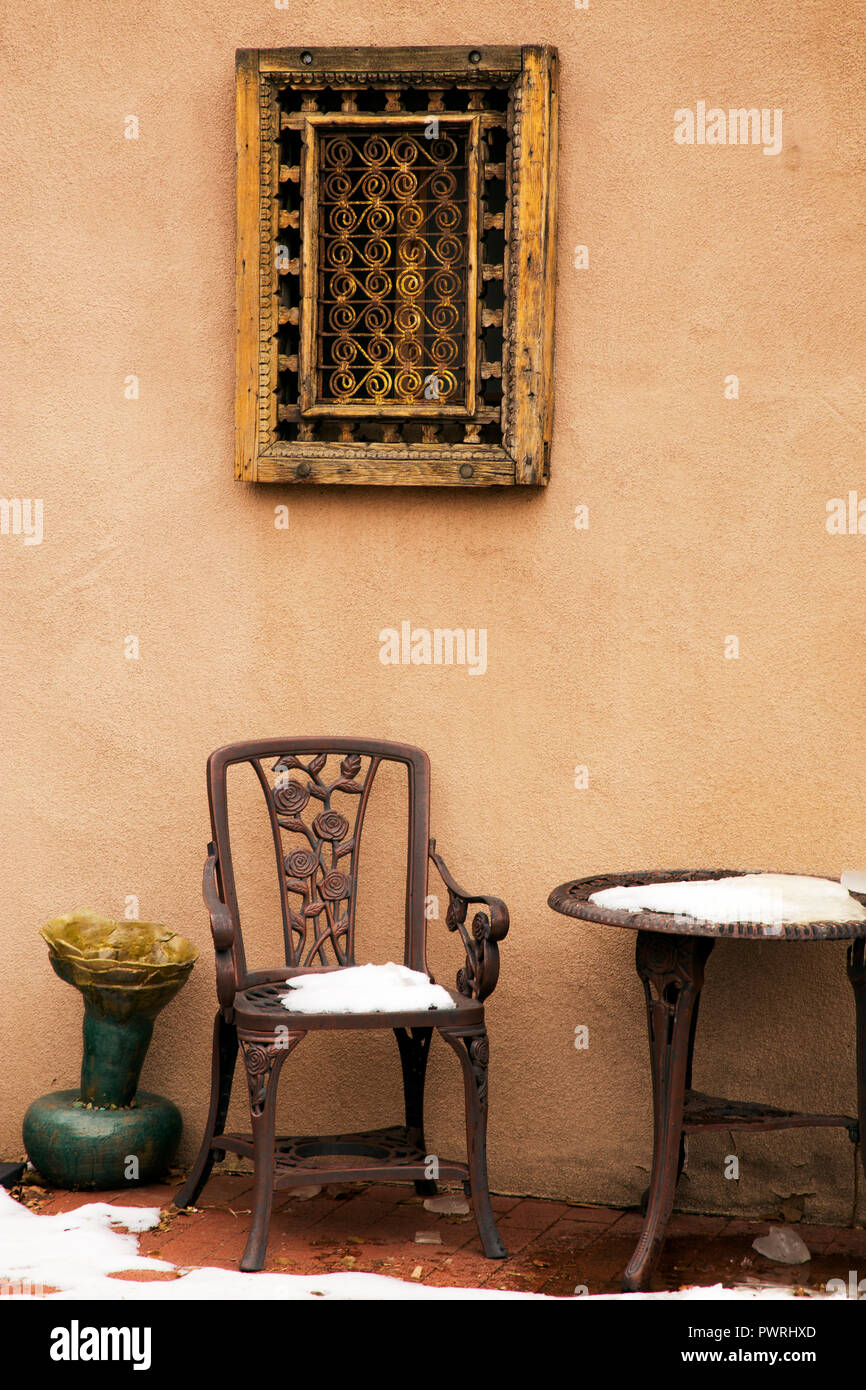 Eisen Stuhl und Tisch unter einem dekorativen Fenster abdecken, Santa Fe,  New Mexico Cast Stockfotografie - Alamy