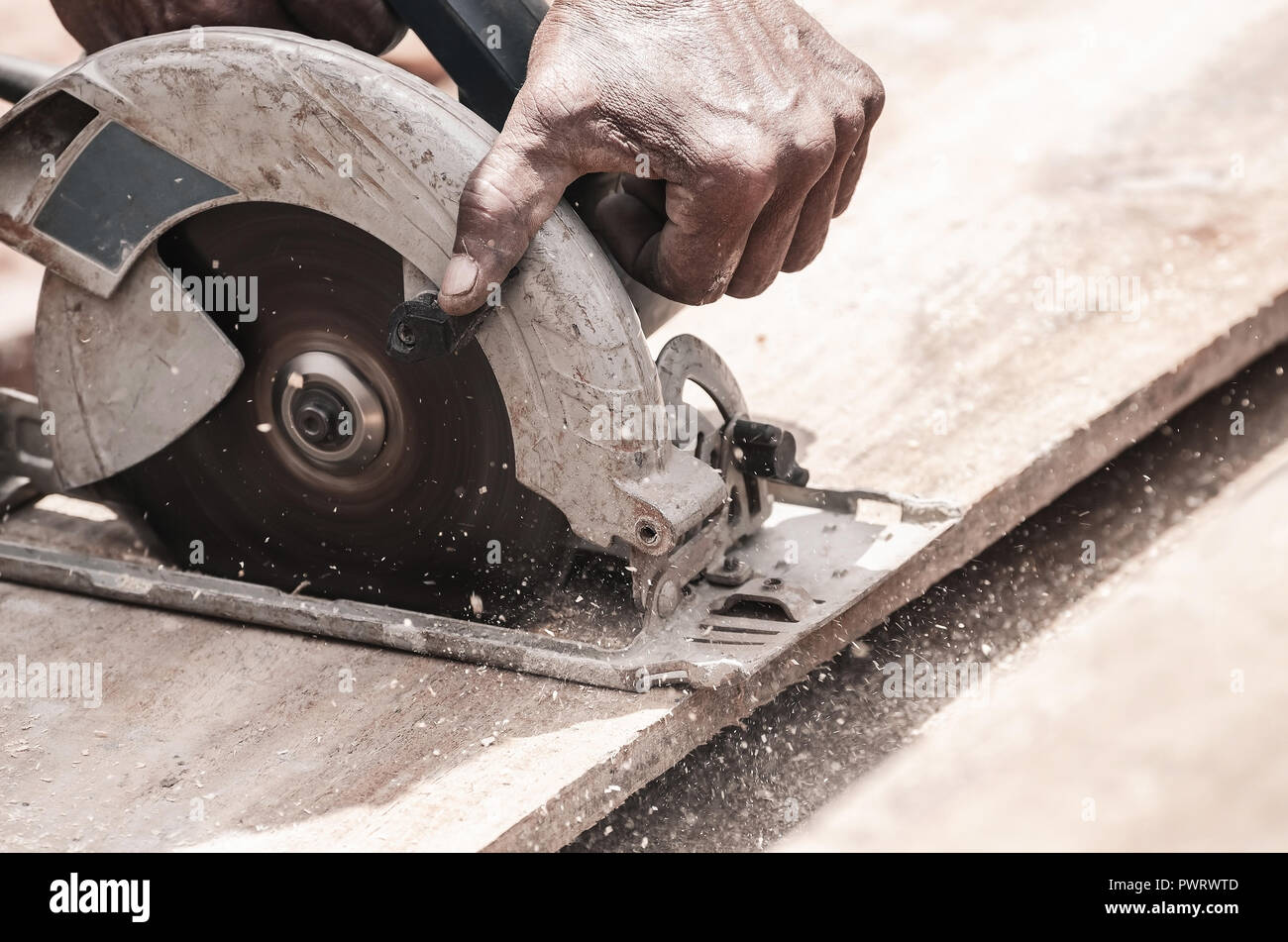 Hand eines Zimmermanns mit einer Kreissäge ein Holzbrett zu schneiden.  Werkzeug Holz zu sägen. Tischlerei Werkzeug. Elektrische Säge, rundmesser  Stockfotografie - Alamy