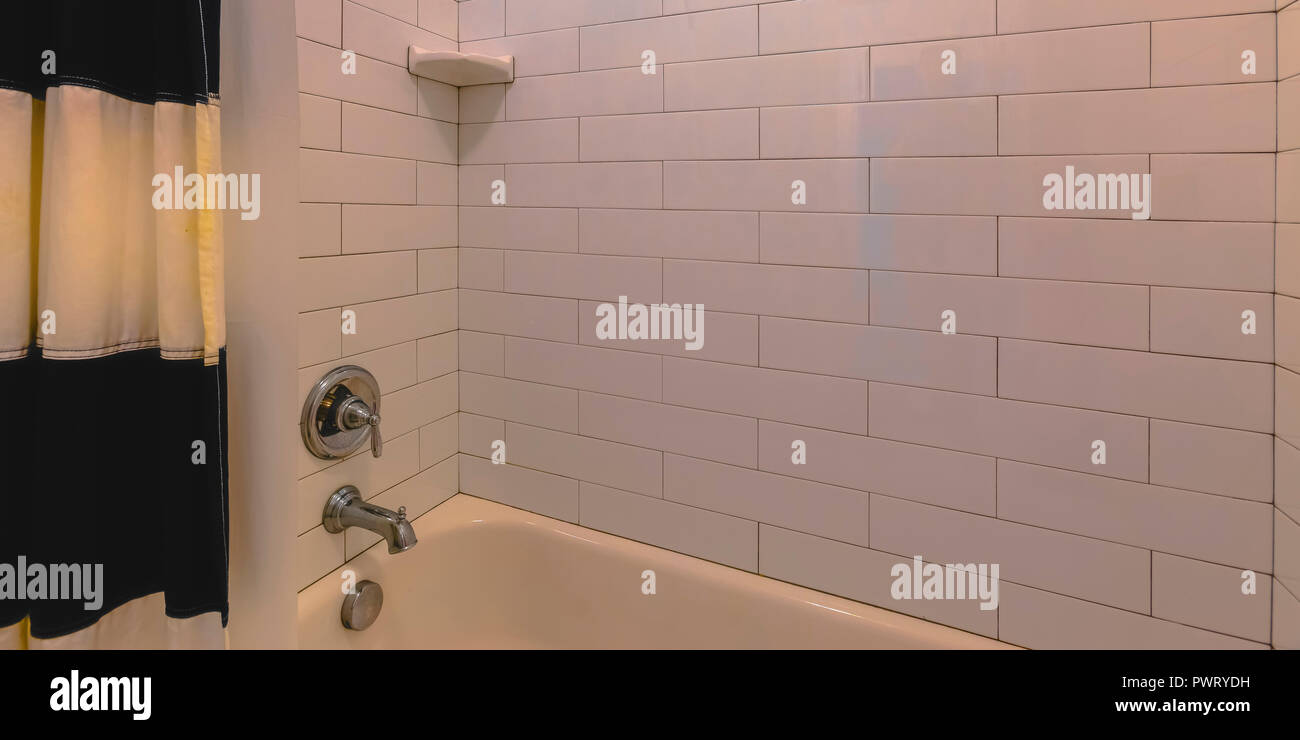 Badezimmer mit Badewanne und weiß gefliesten Wand Stockfoto
