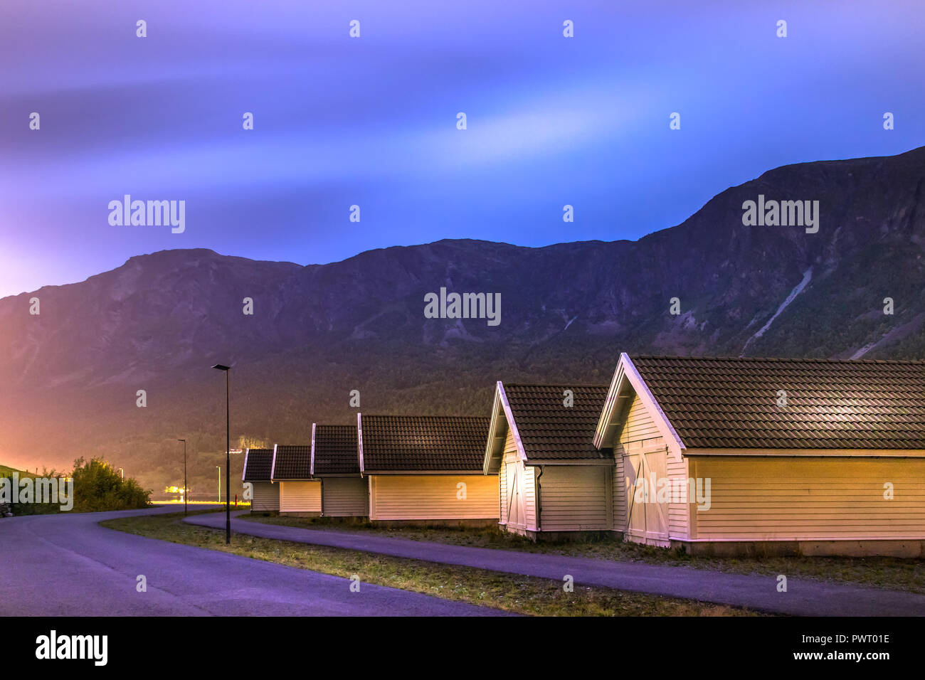 Blick auf die Küste Straße Fv 331 und Holzhäuser in der Nacht im Hafen von Skjolden Dorf, Glanz, Norwegen. Stockfoto