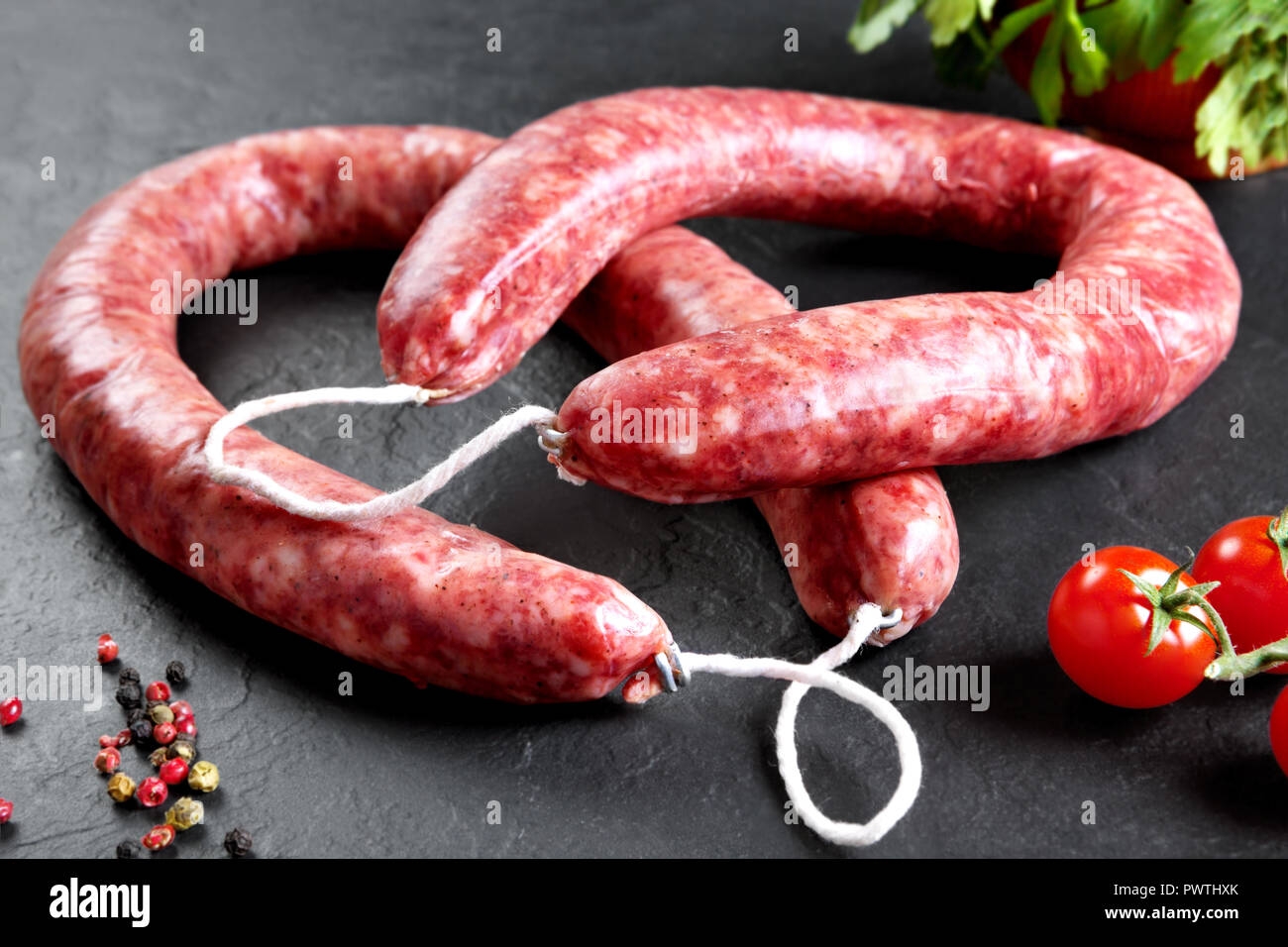 Roh- und frisches Fleisch. Frische Würste und Hähnchenfleisch bereit zu Kochen. Schwarzer Schiefer Hintergrund Stockfoto