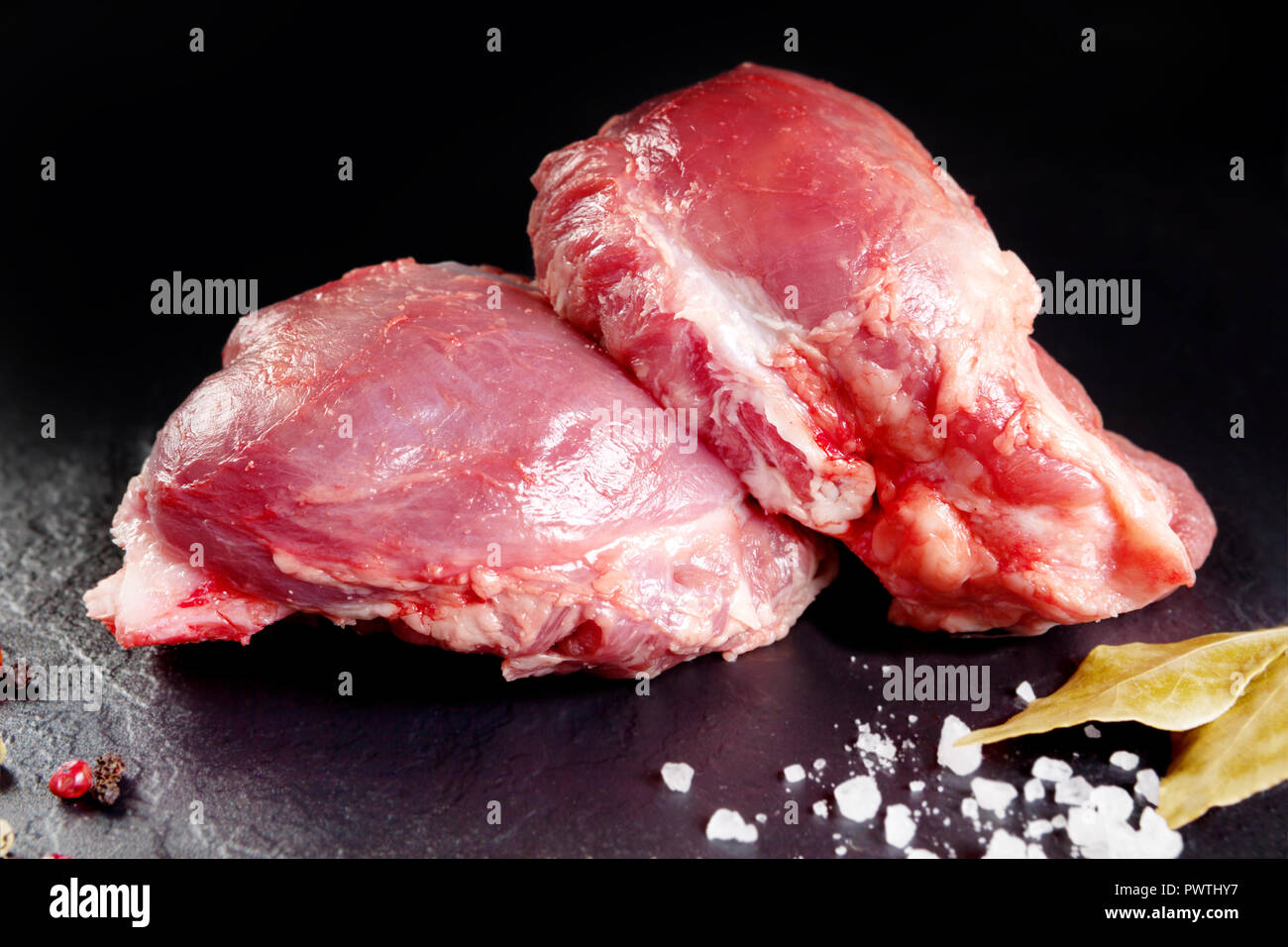 Frisch und rohes Fleisch. Wangen, rote Schweinefleisch bereit, auf dem Grill oder Grill zu kochen. Schwarzer Schiefer Hintergrund Stockfoto