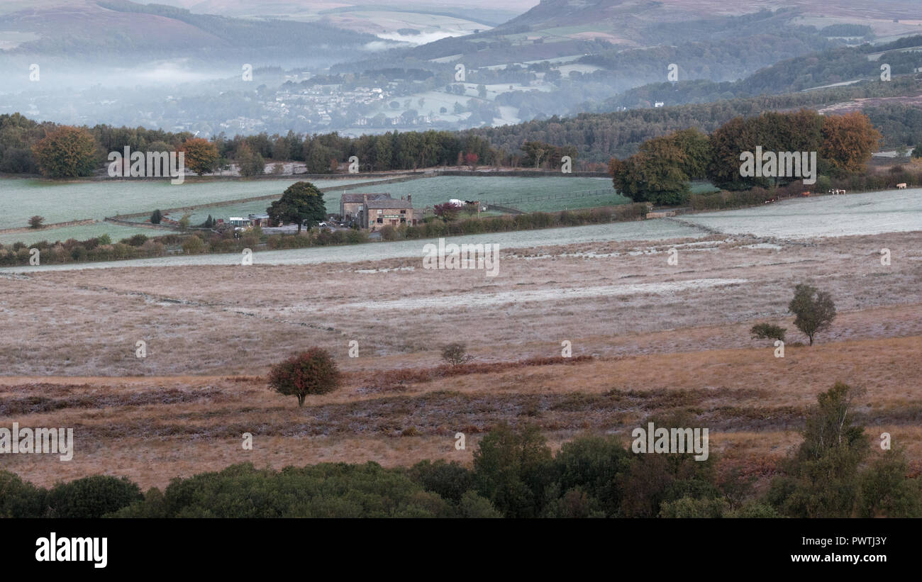 Ein Land Pub mit Hathersage im Hintergrund. Frost ist auf dem Boden und Nebel im Tal hängt. Stockfoto