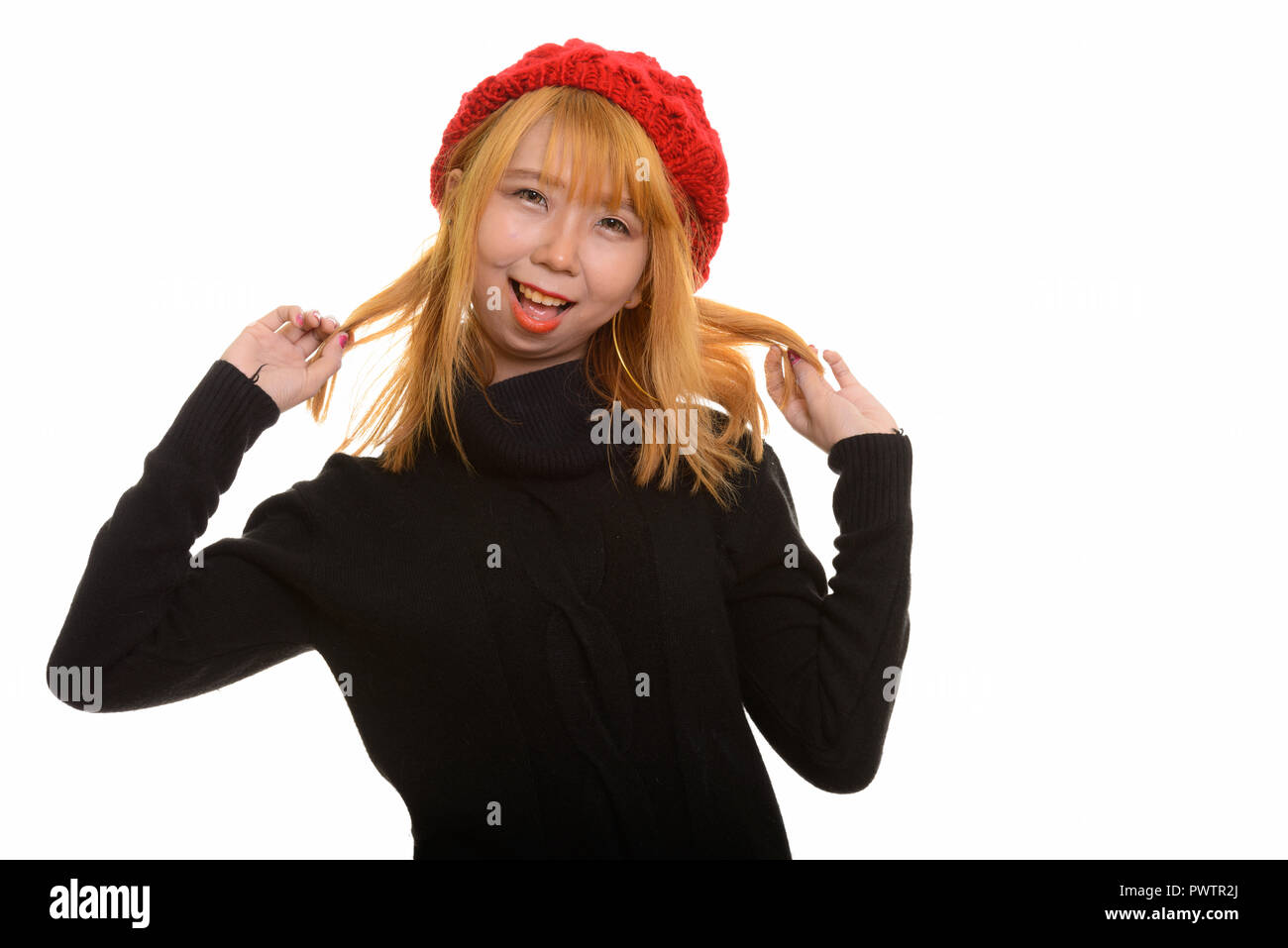 Junge asiatische Frau glücklich lächelnd und Spielen mit Haar Stockfoto