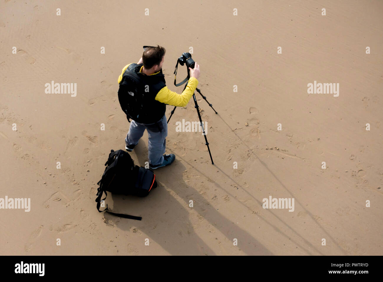 Landschaft Fotograf auf Saltburn Strand Einrichtung seine Kamera auf einem Stativ auf Saltburn Strand Stockfoto