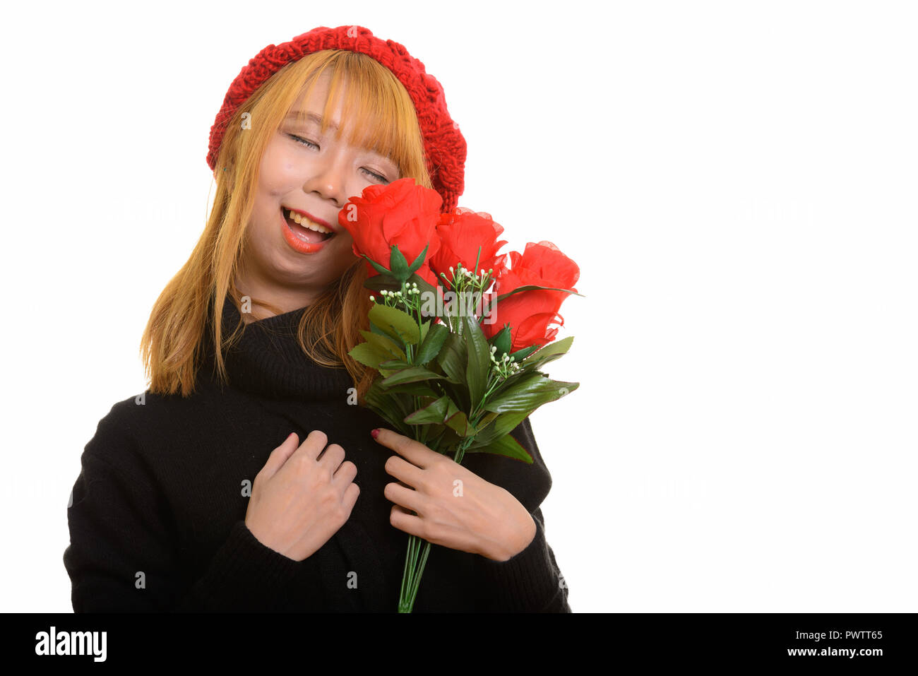 Junge asiatische Glücklich lächelnde Frau mit geschlossenen Augen halten roten Ros Stockfoto