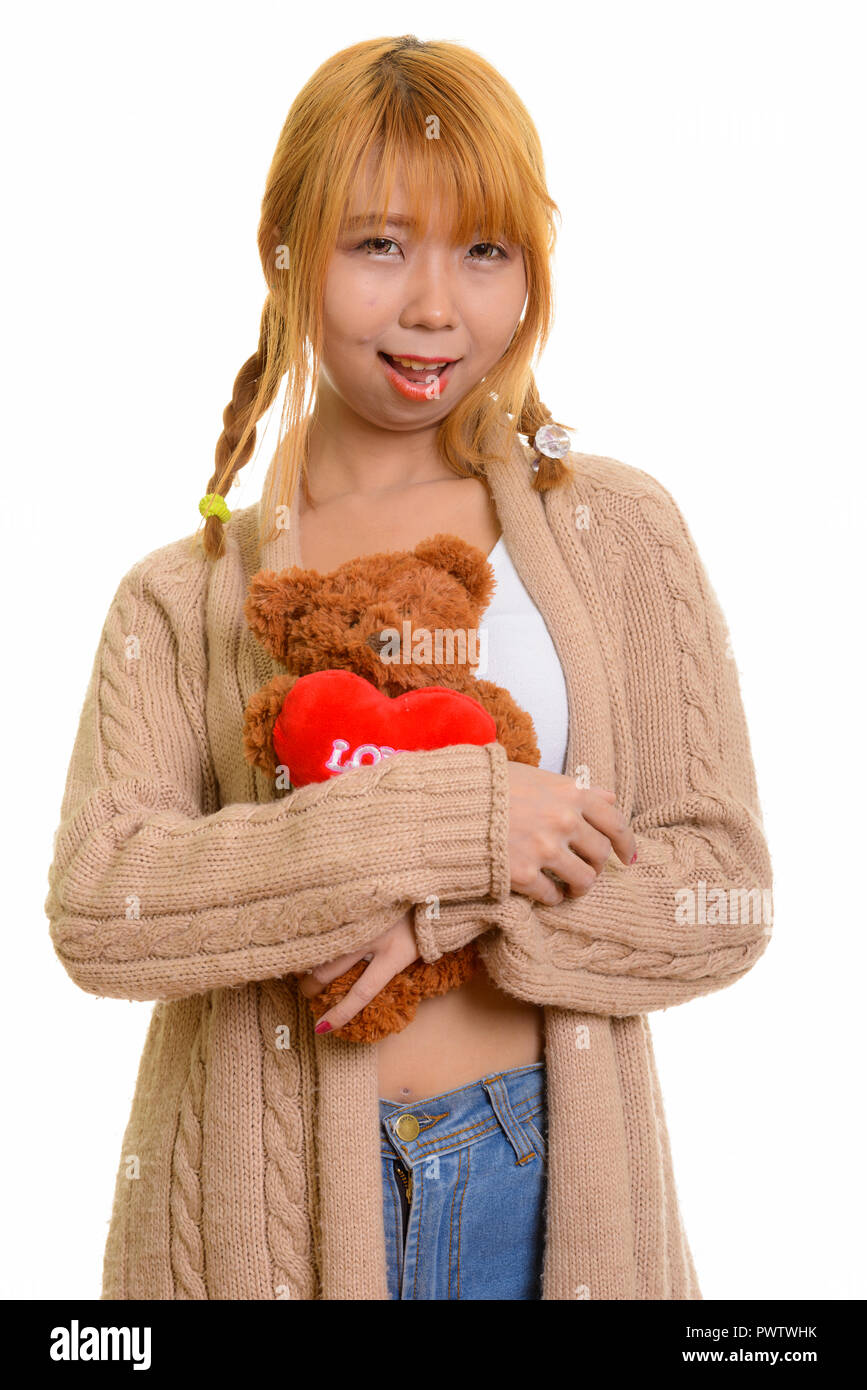 Junge asiatische Frau glücklich lächelnd und umarmen Teddybär mit hören Stockfoto