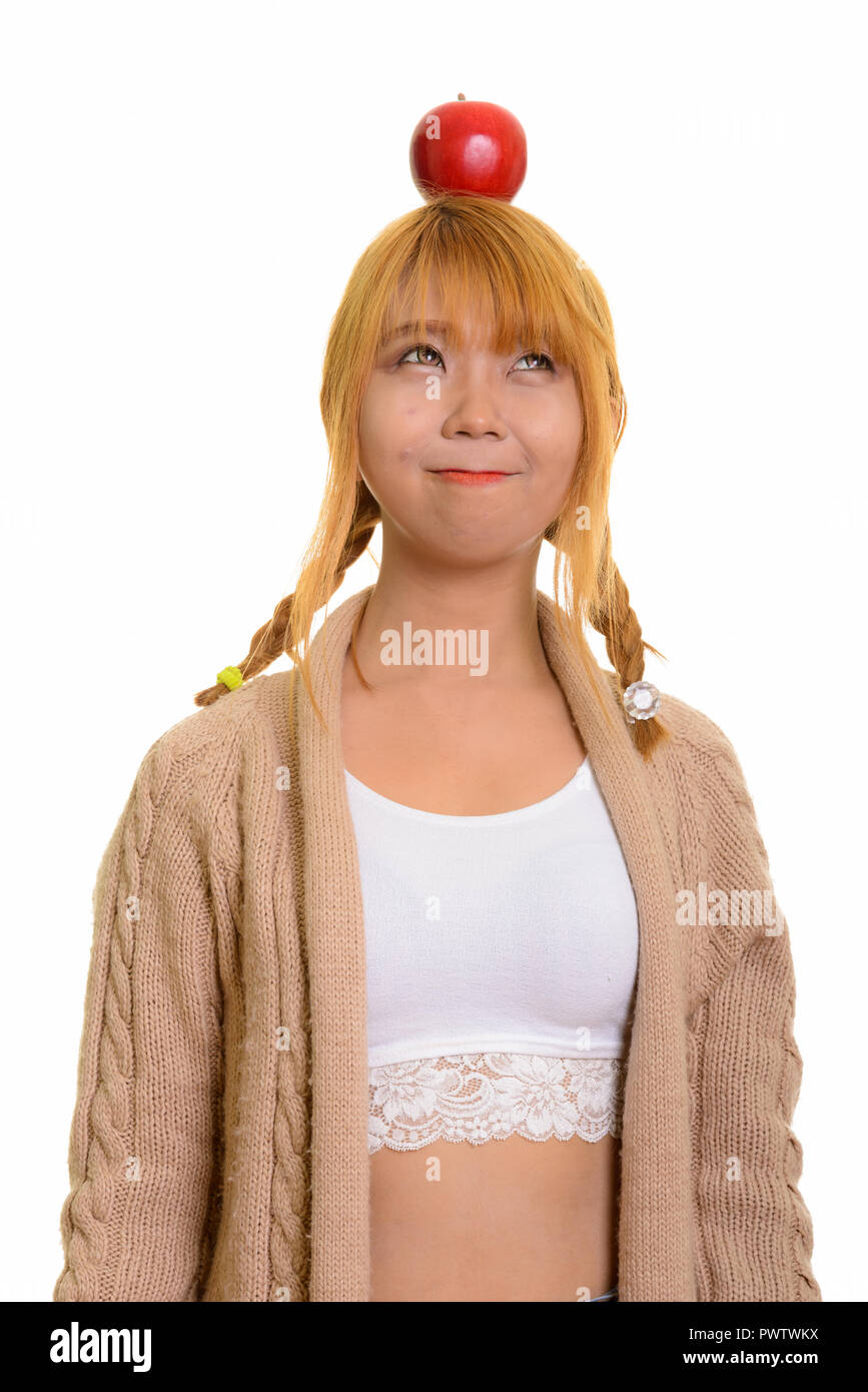 Junge süße asiatische Frau mit Apfel auf dem Kopf Stockfoto