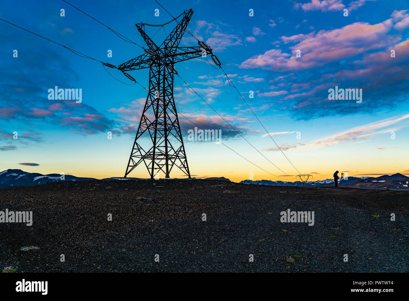 Angesichts der hohen Slhouette Kabel Spannung und ein Fotograf Abends im Hochland von Island Stockfoto