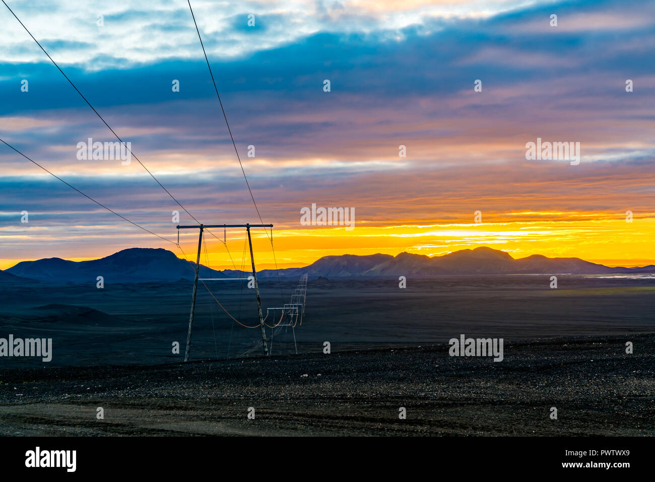 Licht der Sonnenuntergang am Berg mit Hochspannungskabeln in das Hochland von Island im Sommer Stockfoto