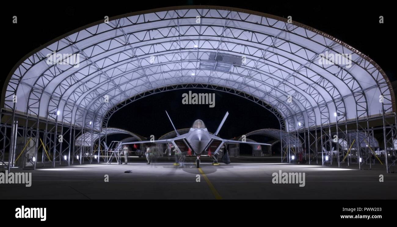 Us Air Force Piloten auf der 94 Flugzeuge Wartungseinheit und der 27 Fighter Wing beenden Prüfung einer F-22 Raptor bei Joint Base Langley-Eustis, Virginia, 26. Juni 2017 vergeben. Das neu erbaute sun Shelter sind mit Lichtern, die das gesamte Flugzeug während der Dunkelheit erhellen, was diejenigen unter Ihnen zu arbeiten, um bessere Visualisierung zu haben. Stockfoto