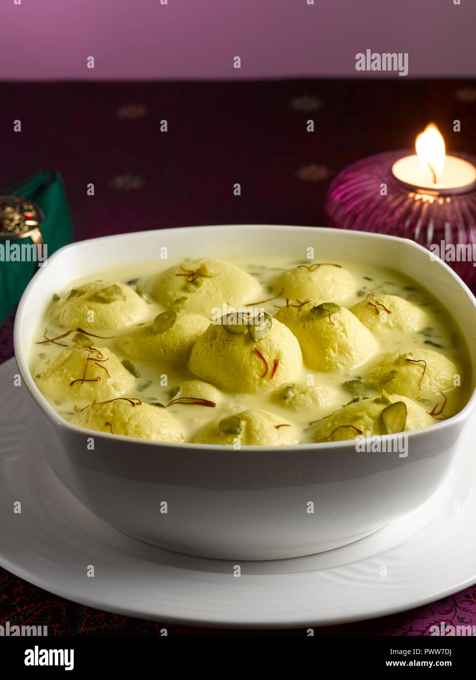 RASMALAI, ein indisches DESSERT AUS HÜTTENKÄSE GETRÄNKT IN SÜSSEN SAFRAN MILCH UND garniert mit Pistazien Stockfoto