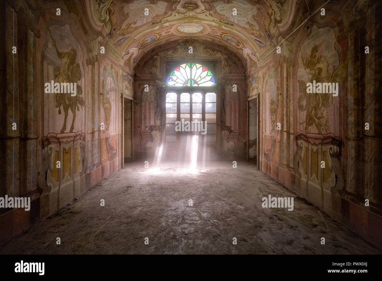 Innenansicht der ein Zimmer in einem verlassenen Villa in Italien mit Fresken und Lichtstrahlen Filterung durch die Tür. Stockfoto