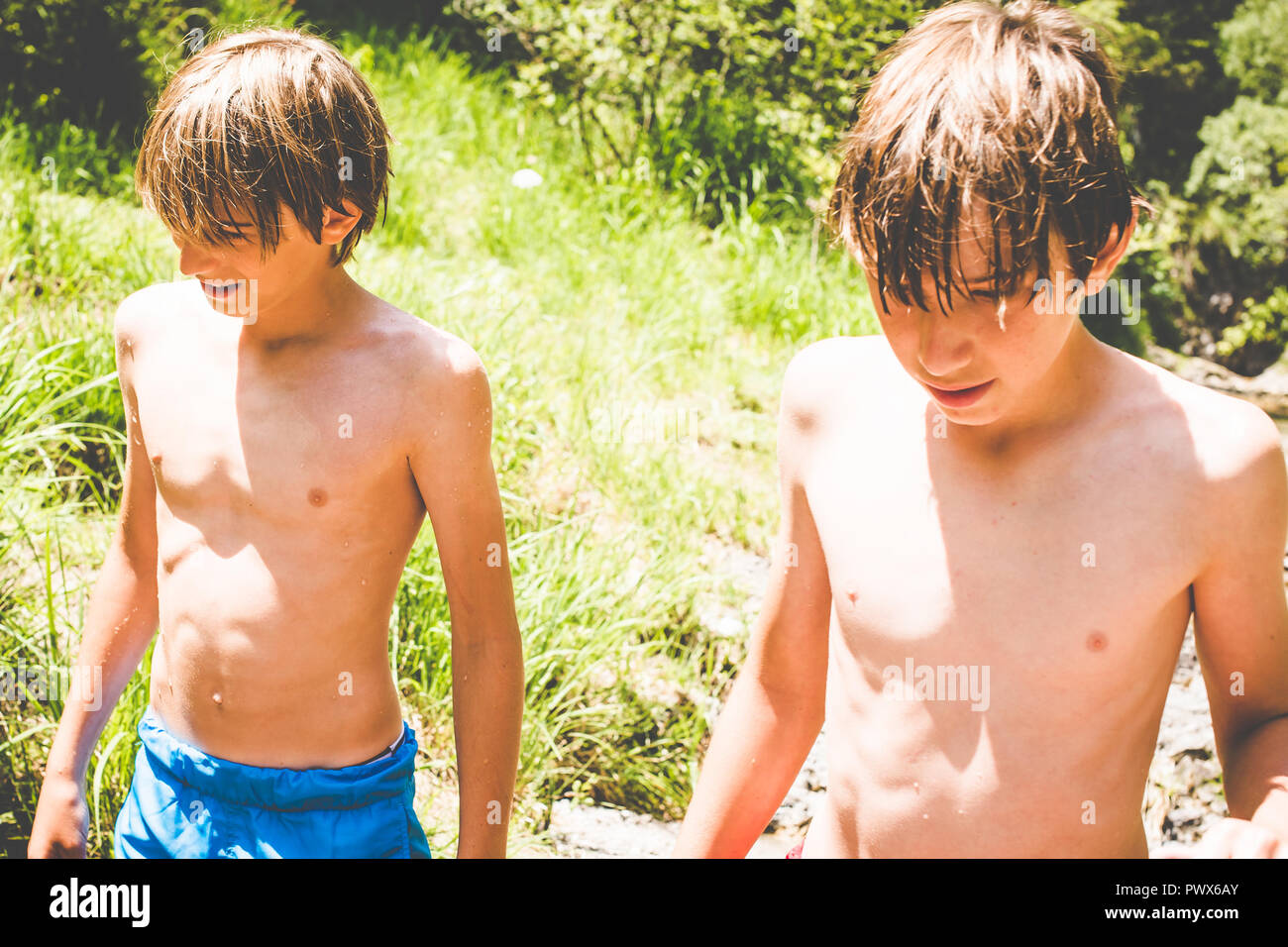 Die Jungen haben Spaß an dem kleinen Fluss - Outdoor Aktivitäten im Sommer Stockfoto