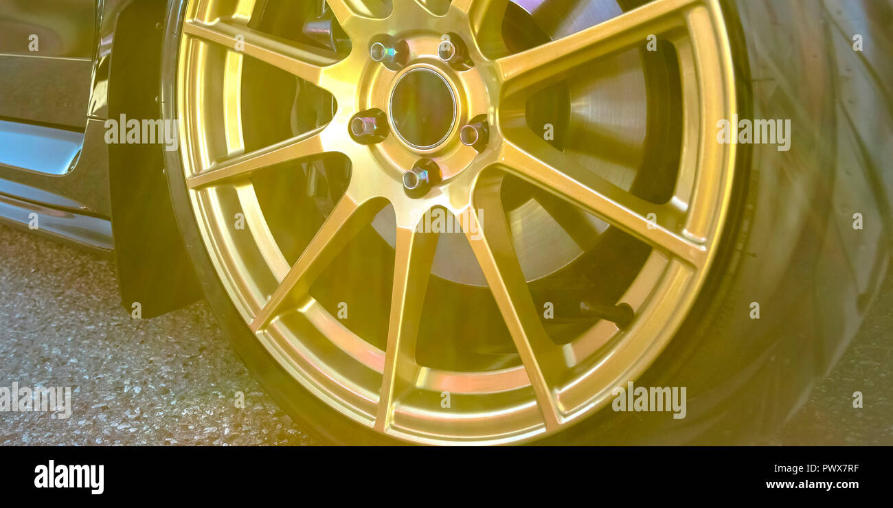 Reifen Felge mit Bremsscheibe zwischen Gold Speichen gesehen Stockfoto