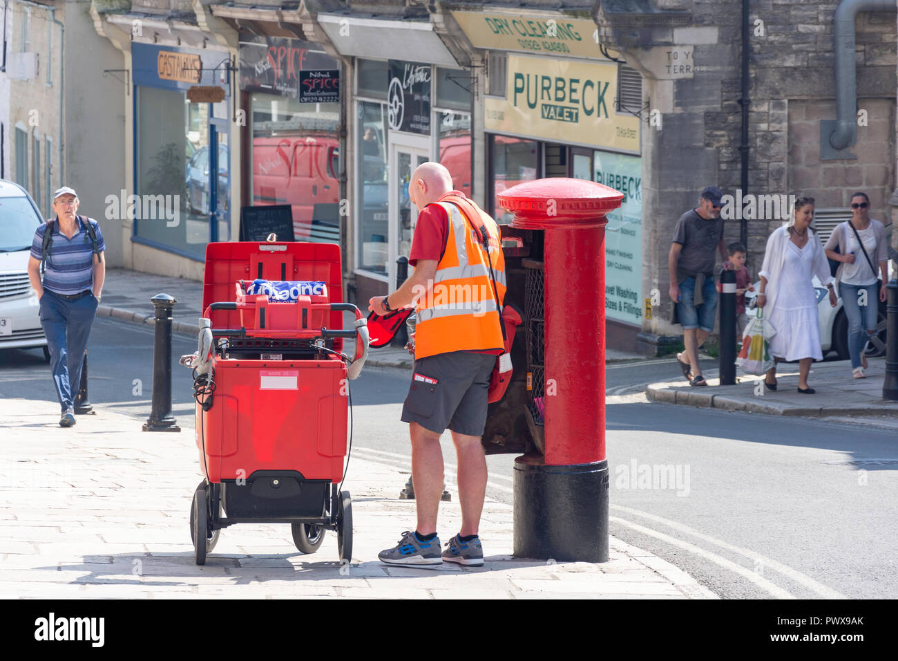 Royal Mail Postbote beim Entleeren eines Post Box, High Street, Swanage, Isle of Purbeck, Dorset, England, Vereinigtes Königreich Stockfoto