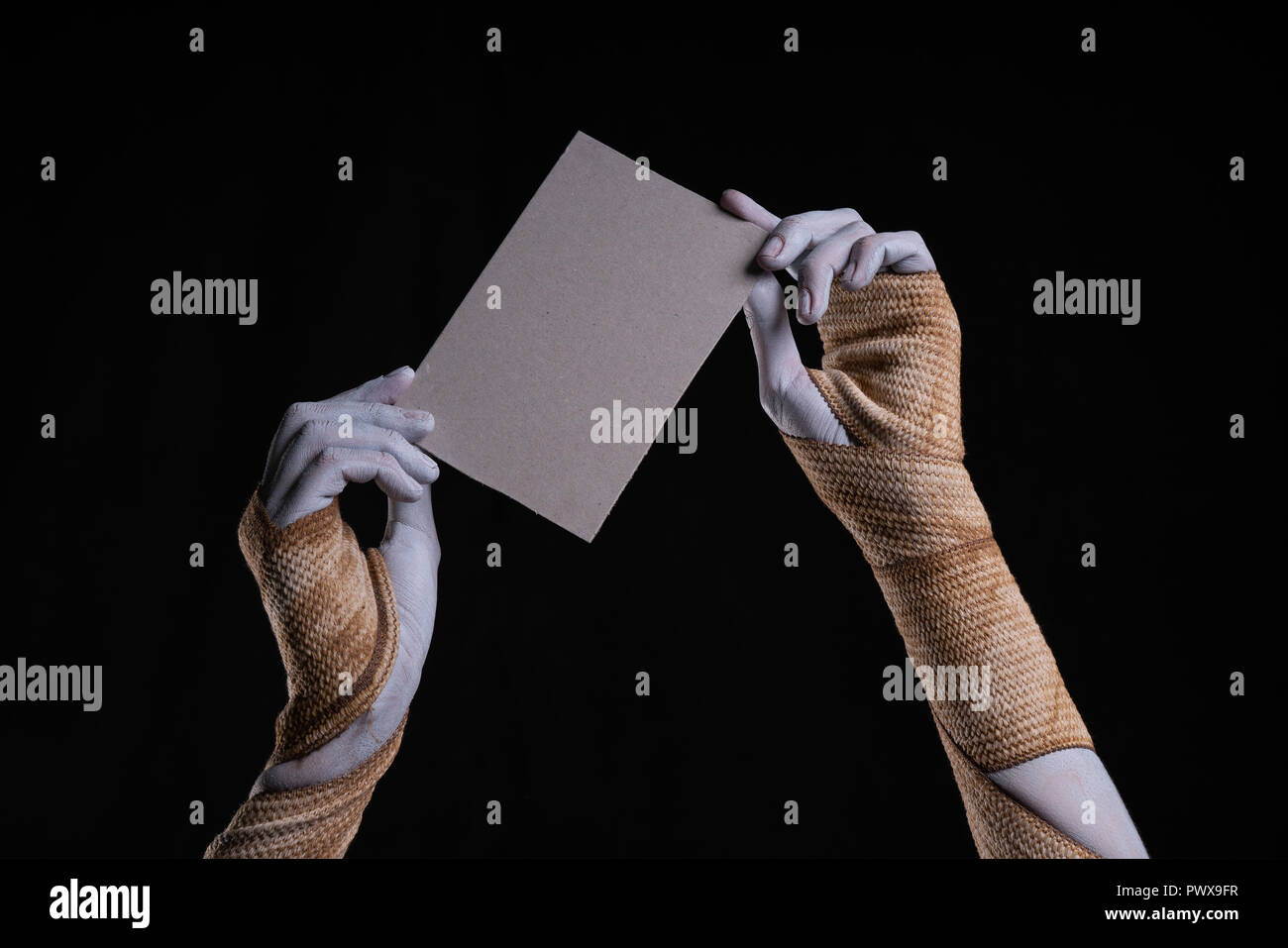 Bandagierten Mumie Hände halten ein Stück Pappe, Halloween Theme Stockfoto