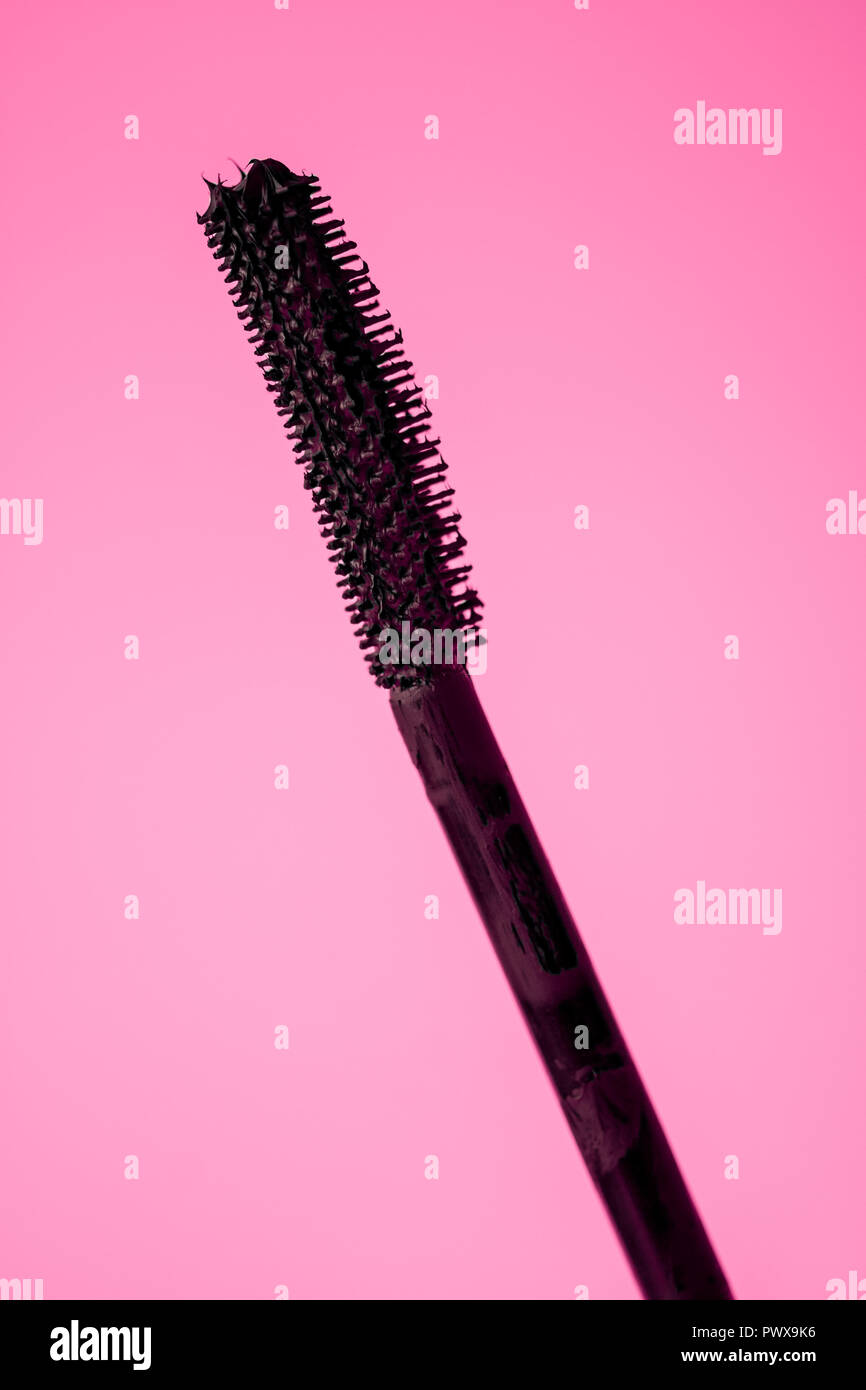 Schwarze Wimperntusche auf rosa Hintergrund einstellen Stockfoto