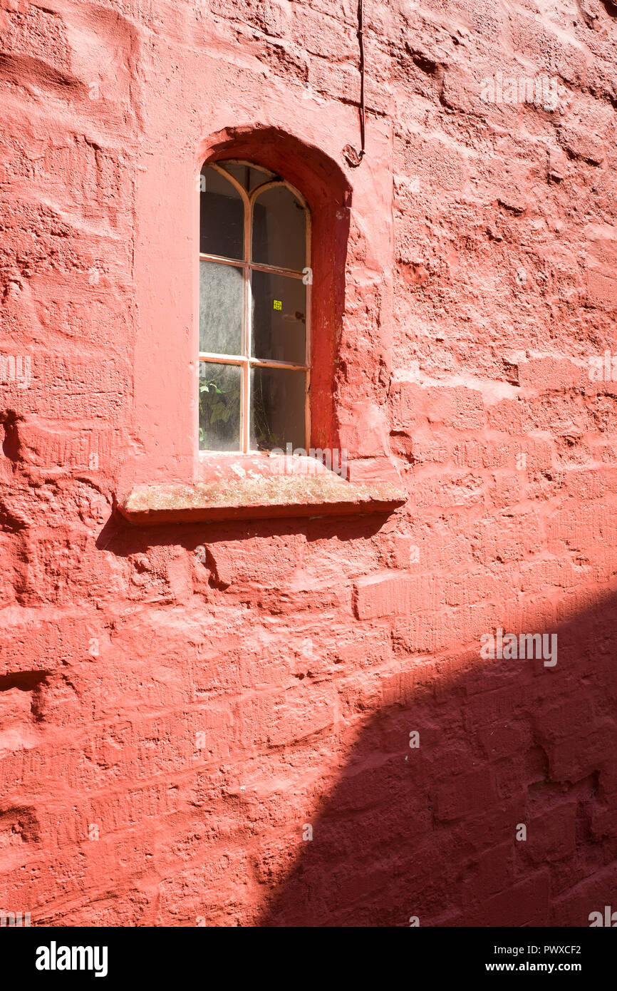Ein kleines Fenster in eine rot gestrichene Wand in einem alten Stadthaus in Calne Wiltshire England Grossbritannien Stockfoto Ein kleines Fenster in eine rot gestrichene Wand in einem alten Stadthaus in Calne Wiltshire England Grossbritannien Stockfoto