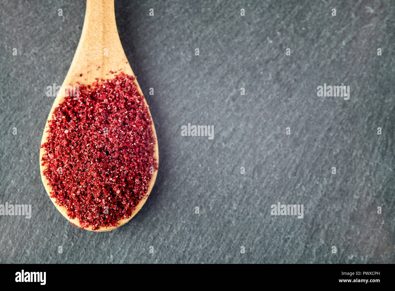 Boden sumac Spice Pulver in Löffel aus Holz. Ansicht von oben mit der Kopie Raum Stockfoto