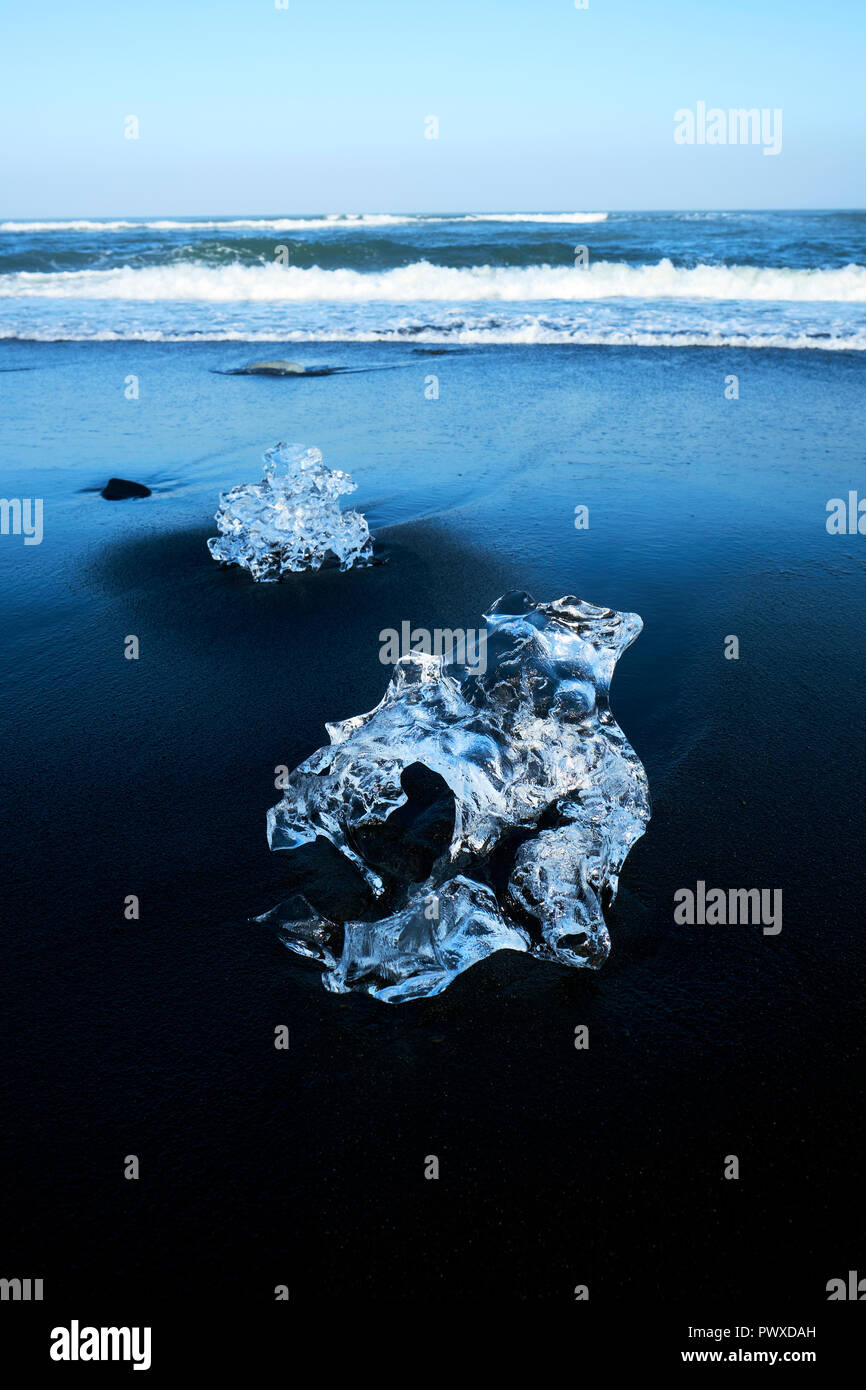 Schmelz angeschwemmte Eisberg Fragmente auf den schwarzen Basalt sand Strand von Jokulsarlon im Süden Islands. Stockfoto