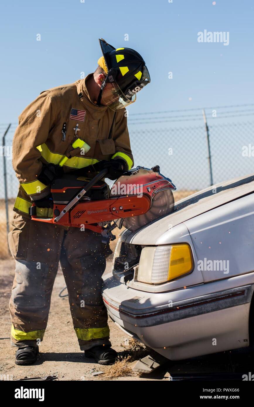 Airman 1st Class Alexander Herrera, 9. Bauingenieur Squadron Feuerwehrmann, verwendet eine Kreissäge in die Haube eines Fahrzeugs bei einer Rettung aus verunfallten Fahrzeugen Übung an der Beale Air Force Base, Calif., 29. Juni 2017 zu schneiden. Feuerwehr wird persönliche Schutzausrüstung tragen, sich vor den Gefahren der Not Szenen wie Feuer, Benzin und biohazards zu schützen. Stockfoto