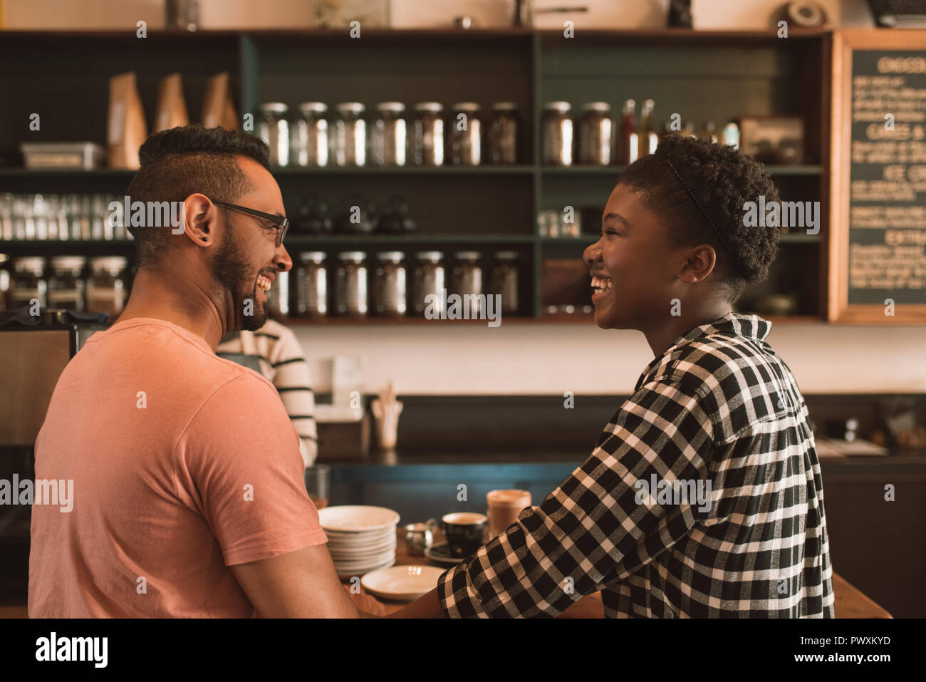 Lächelnde junge Paar Kaffee zusammen bestellen In einem Café Stockfoto