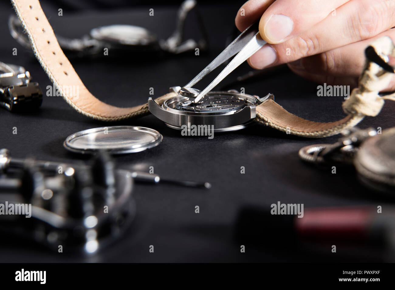 Der Austausch einer Uhrenbatterie mit uhrmacher Tools Stockfoto