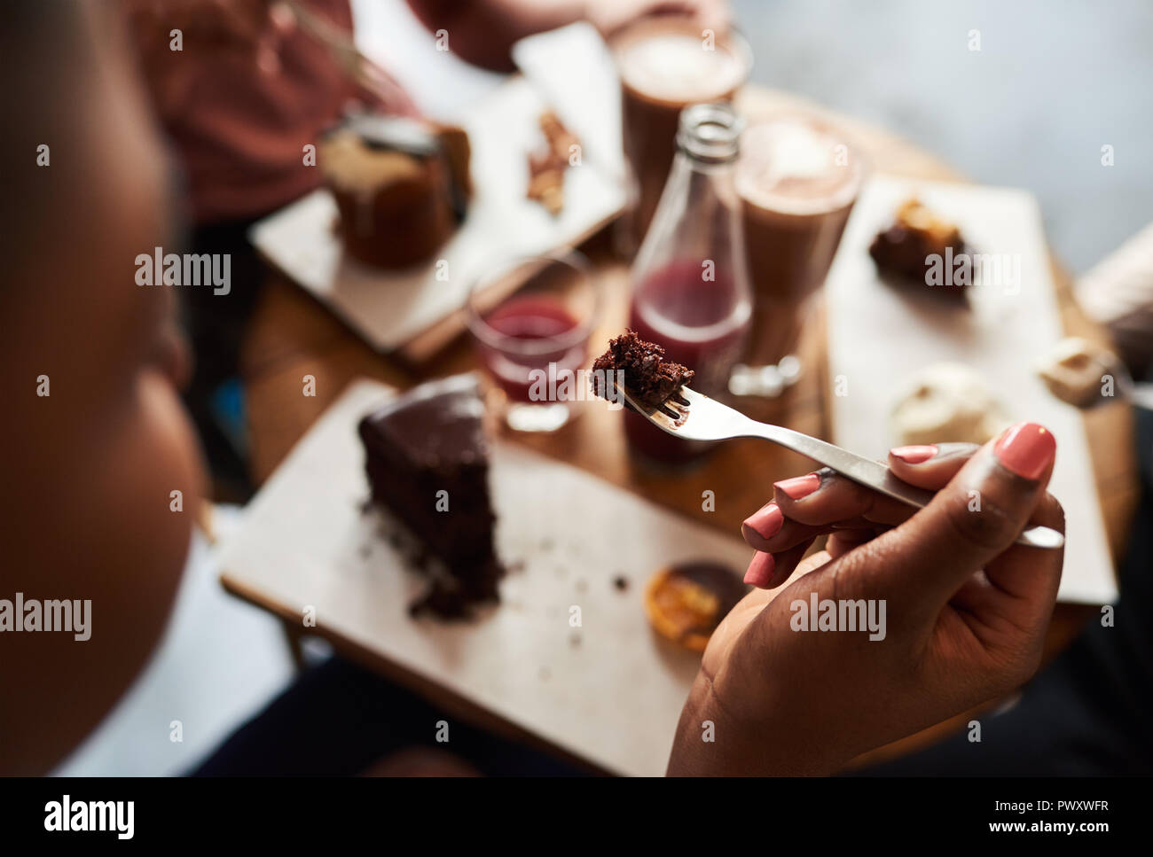 Junge Frau Kuchen essen mit Freunden in einem Cafe Stockfoto