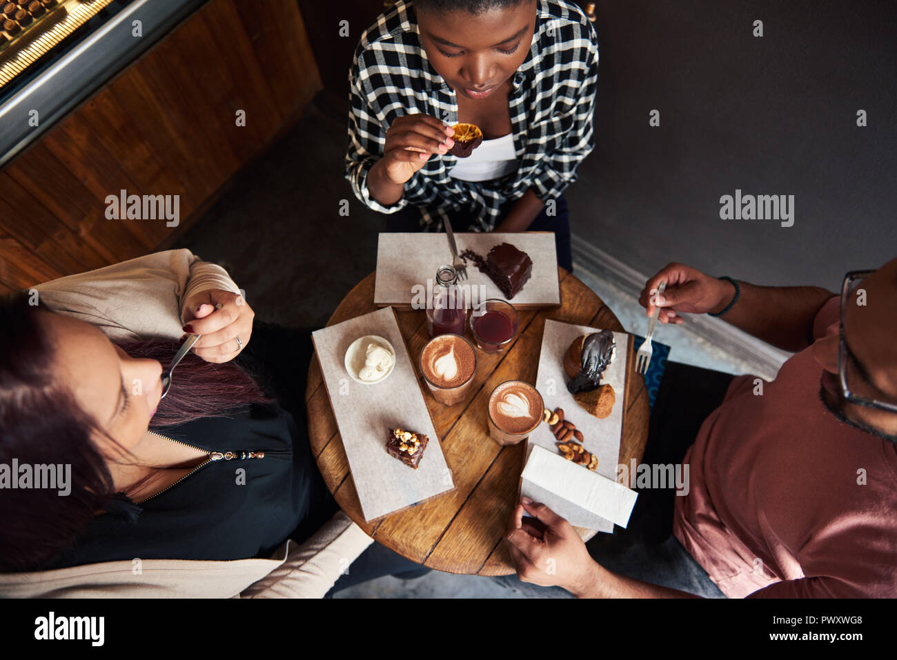 Freunde in einem Café Tisch köstliche Desserts sitzen zusammen Stockfoto