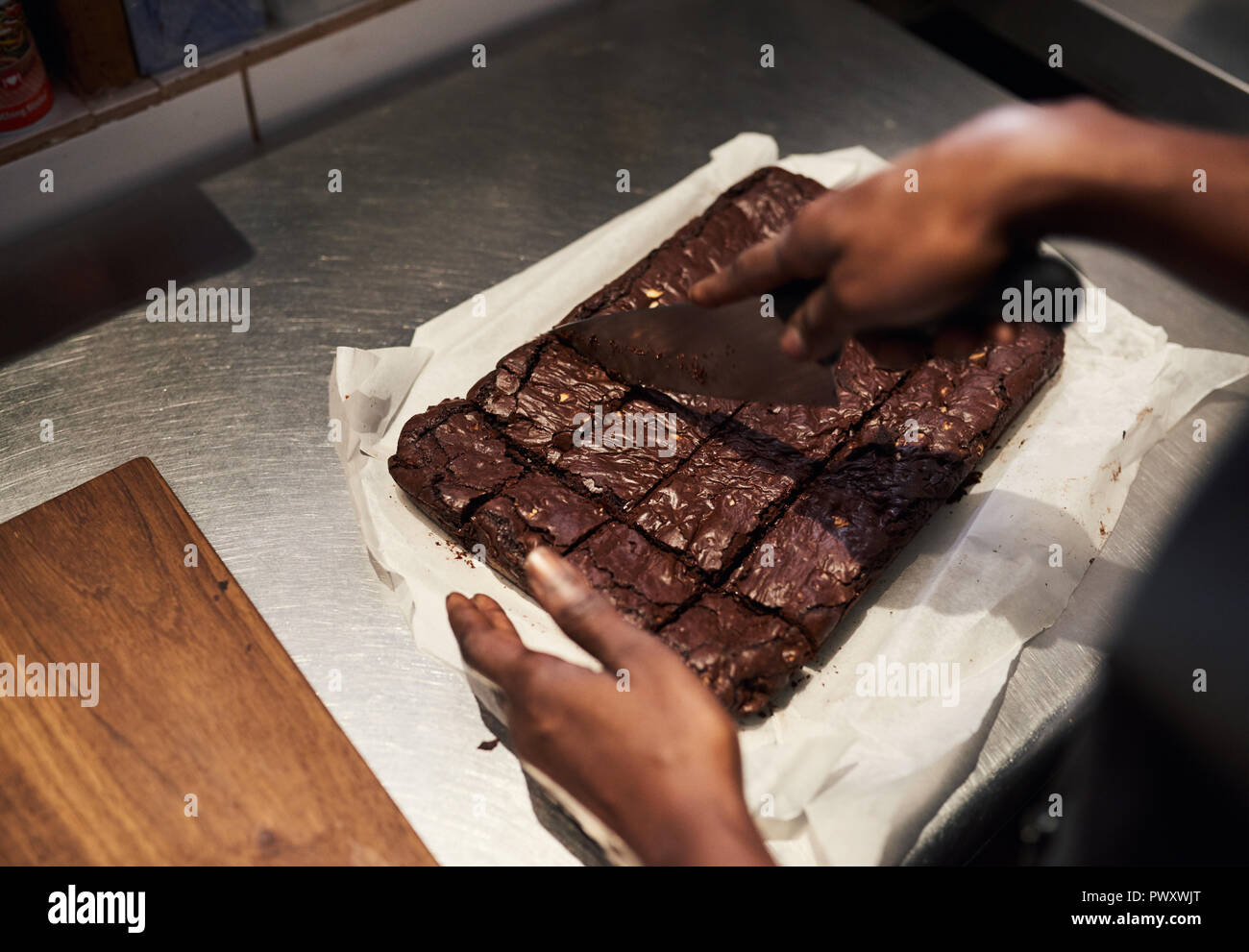 Baker Zerschneiden frischen Brownies in einem Cafe Küche Stockfoto