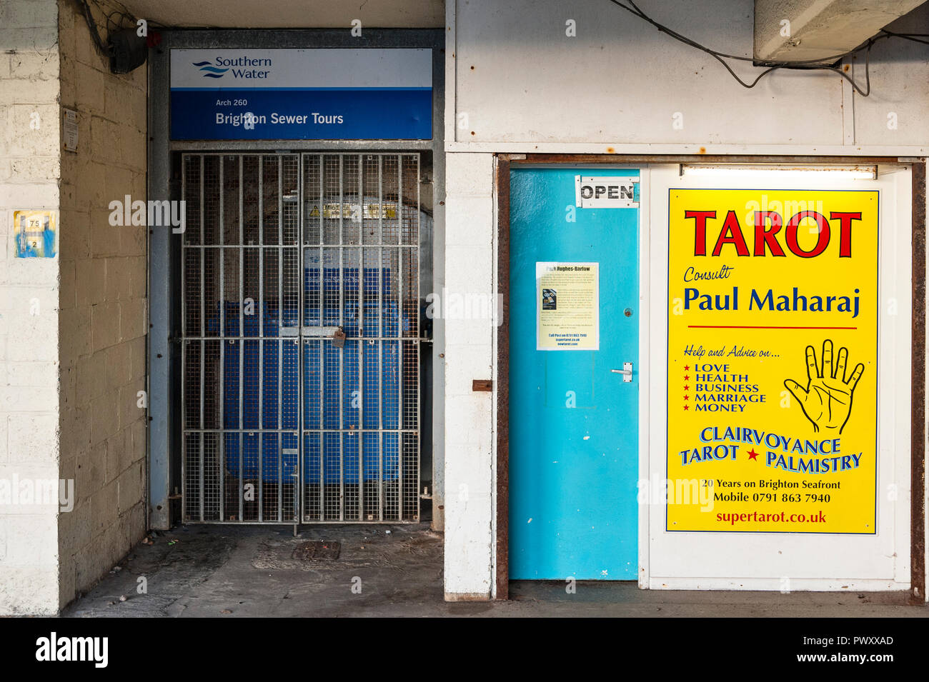 Brighton, East Sussex, UK. Der Eingang für Touren in der Stadt Kanalisation, neben einem Plakat werbung tarot Lesungen und clairvoyancy Stockfoto