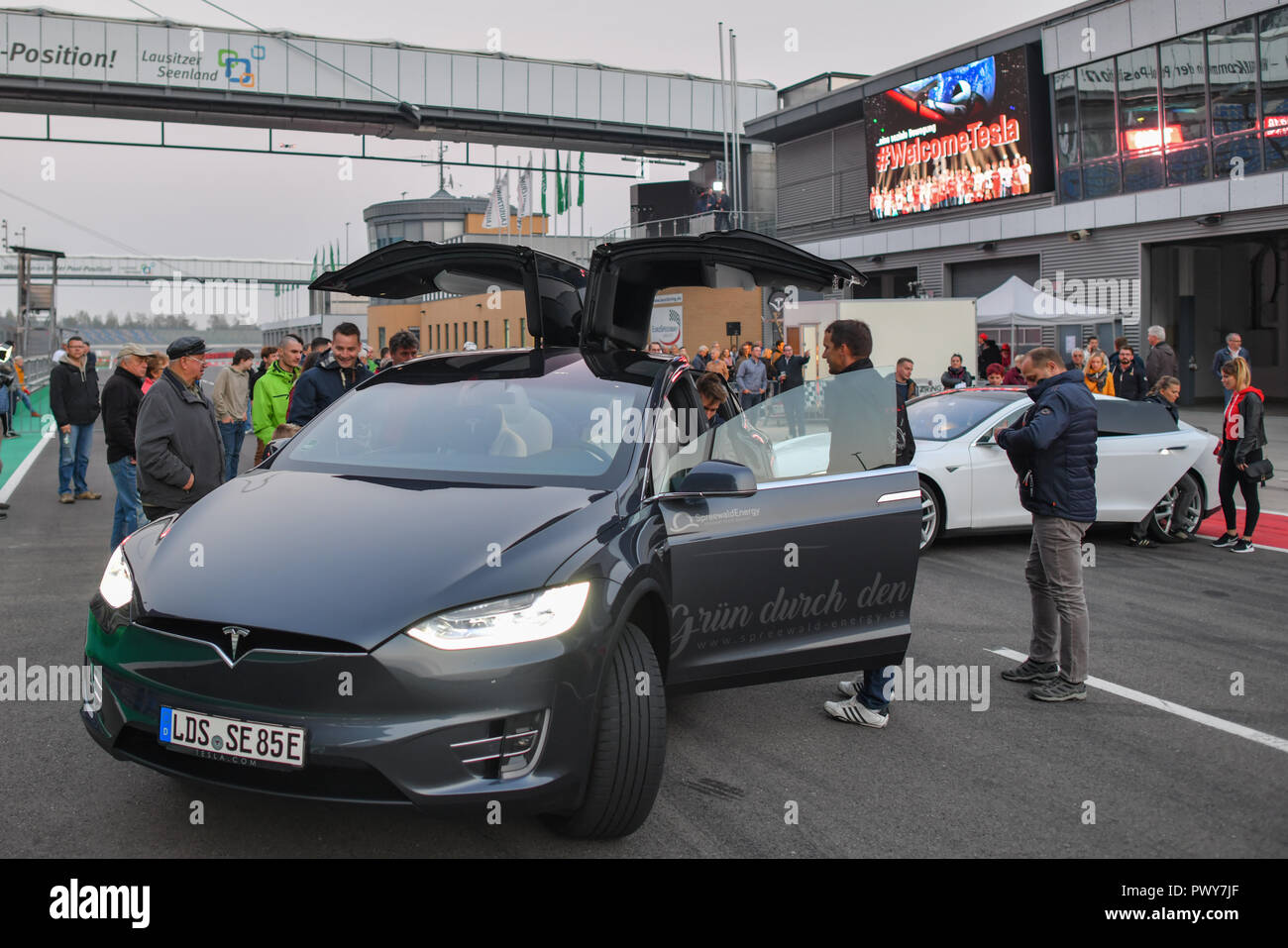 Klettwitz, Deutschland. Okt, 2018 18. Elektroautos der Marke Tesla auf dem Lausitzring während der Kampagne # WelcomeTesla. Während der Werbekampagne für ein Tesla batterie Fabrik in Brandenburg, Lausitzer sind Sie den Himmel mit Taschenlampen und Spotlights. Foto: Patrick Pleul/dpa-Zentralbild/dpa/Alamy leben Nachrichten Stockfoto