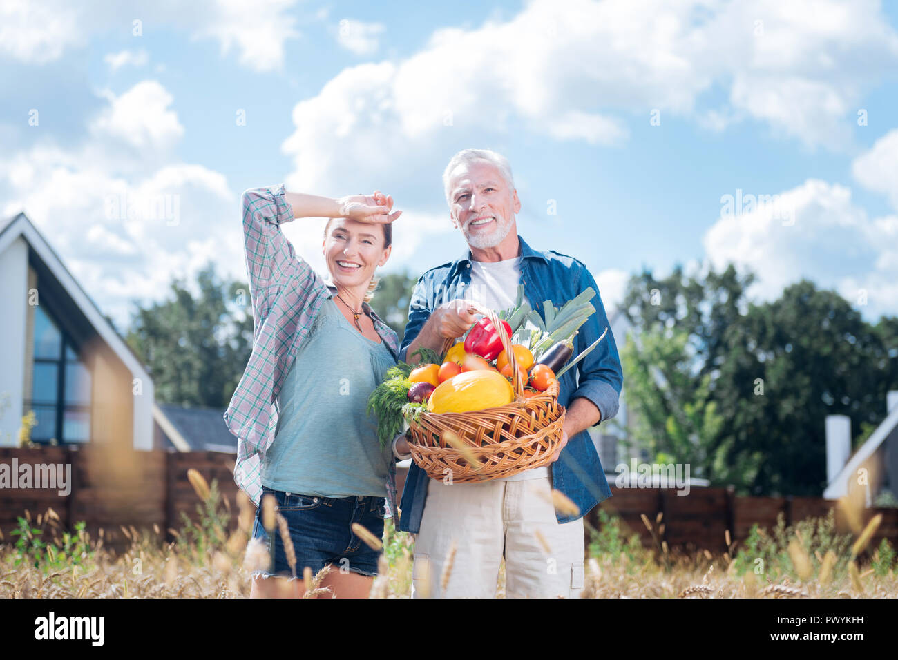 Glücklich strahlenden Paar Gefühl erstaunliche Holding Korb mit Gemüse Stockfoto