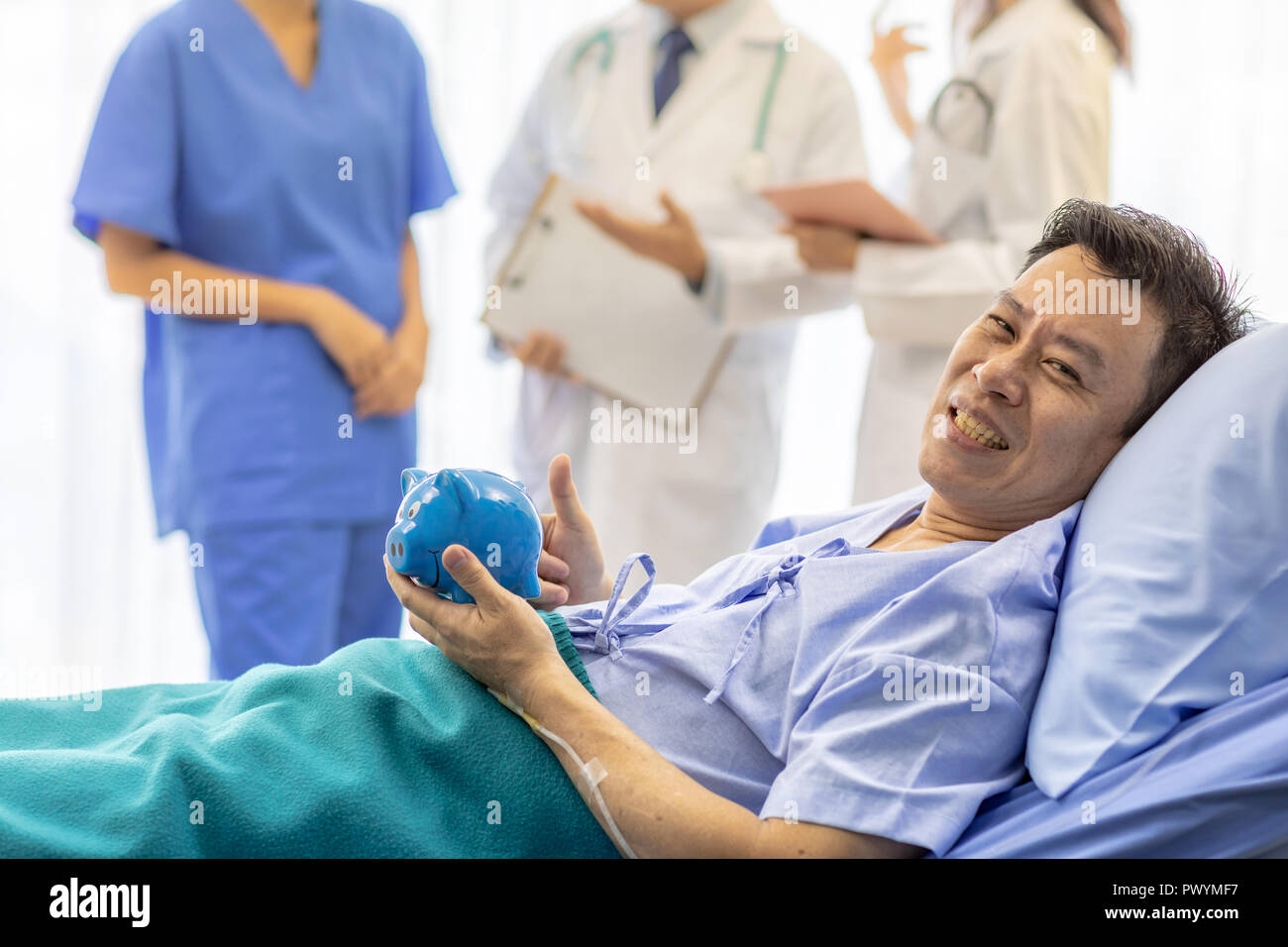 Patient Sparschwein im Bett mit professionellen Team Ärzte im Hintergrund für die Krankenversicherung Konzept Stockfoto