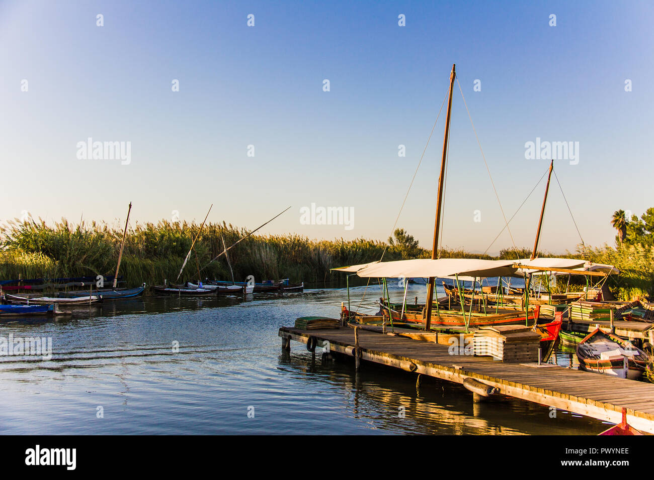 Pier und Fischerboote in "La Albufera" Lagune, bei Sonnenuntergang, in Valencia, Spanien Stockfoto