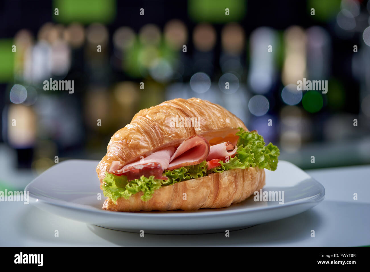 Köstlich knusprige Sandwich mit frischem Gemüse, Schinken und Gemüse bleiben am Tisch im Café. Lecker Angebot croissant für das Essen im Pub vorbereitet. Konzept der leckeren Fast Food und Küche. Stockfoto