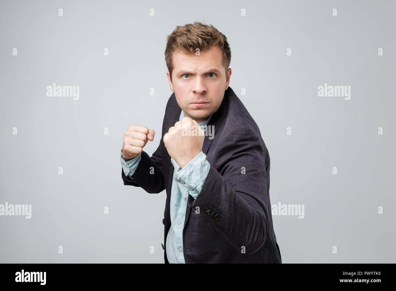 Zuversichtlich Geschäftsmann bereit für den Kampf um einen grauen Hintergrund. Ich bin bereit, sie in Angriff zu nehmen Stockfoto